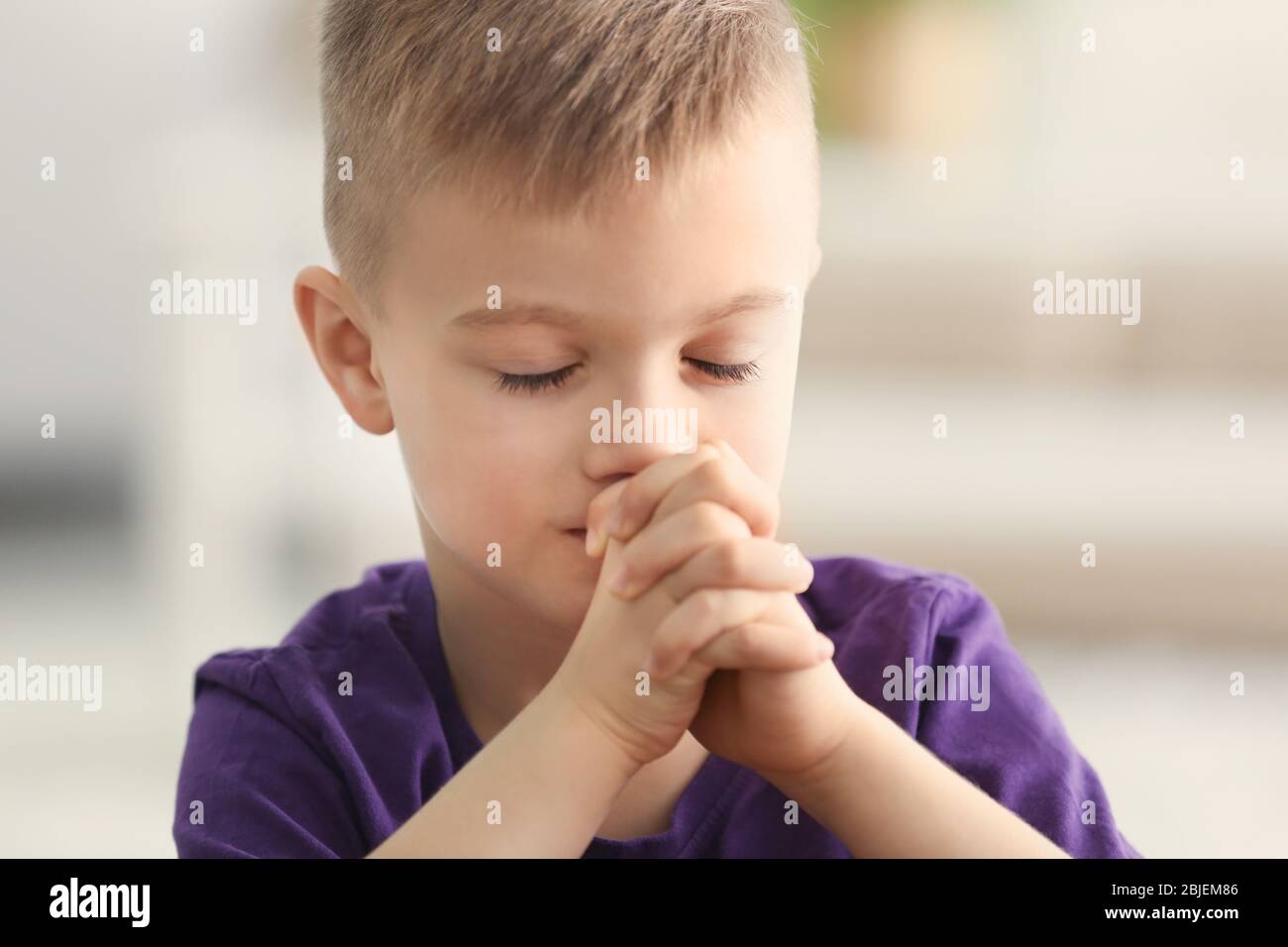 Cute little boy praying at home Stock Photo - Alamy