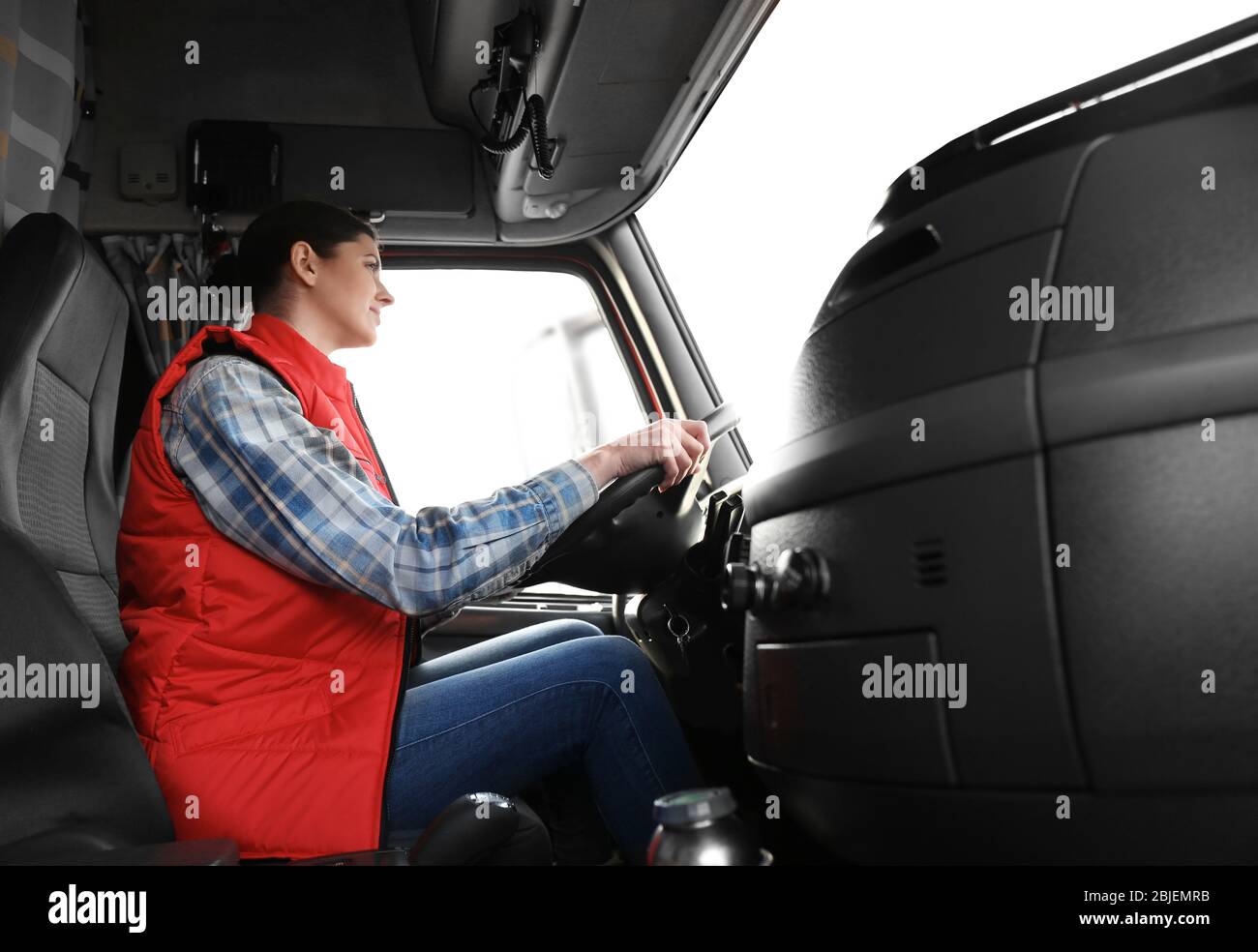 Young female driver sitting in cabin of big modern truck Stock Photo ...