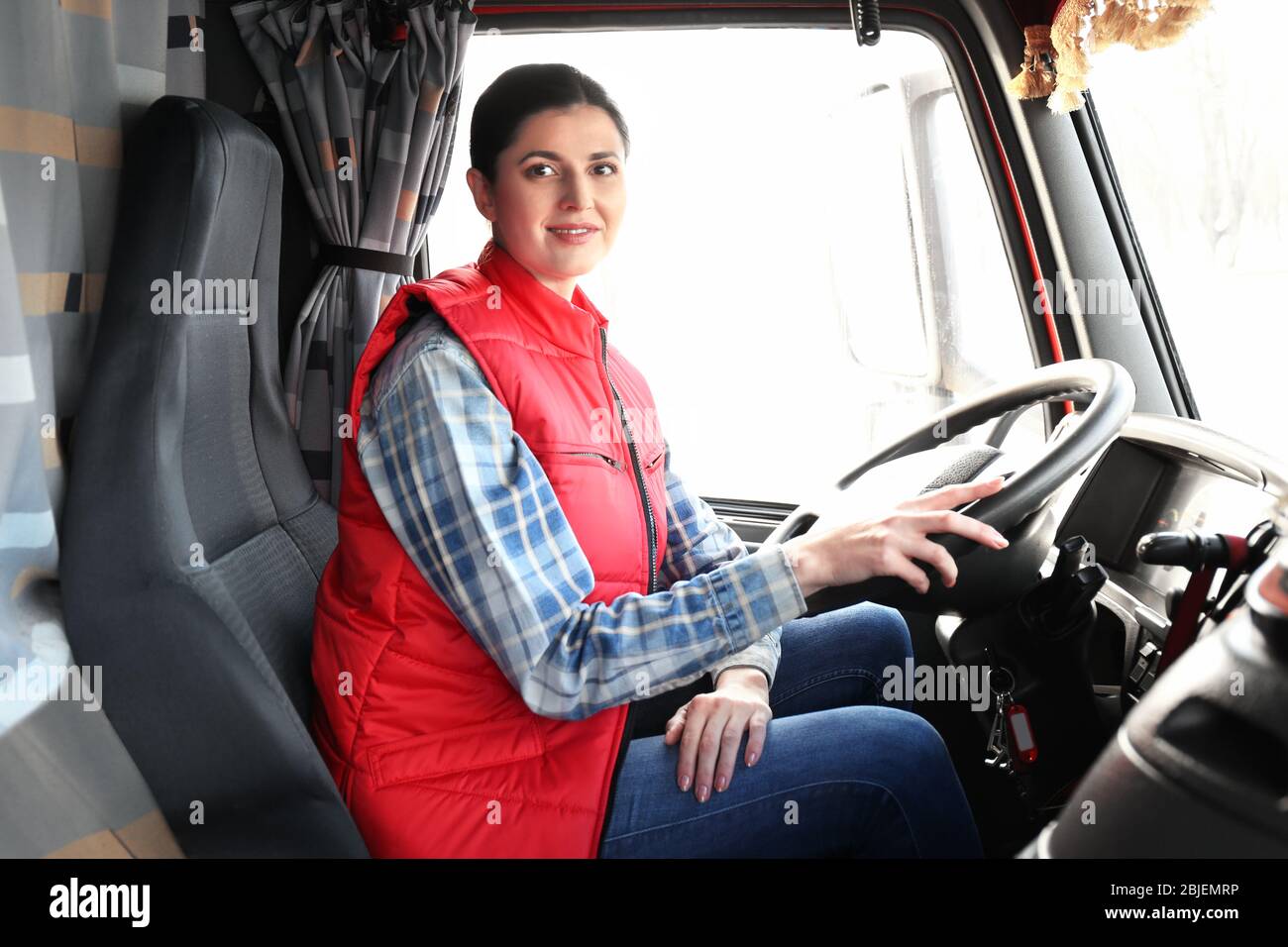 Young female driver sitting in cabin of big modern truck Stock Photo ...