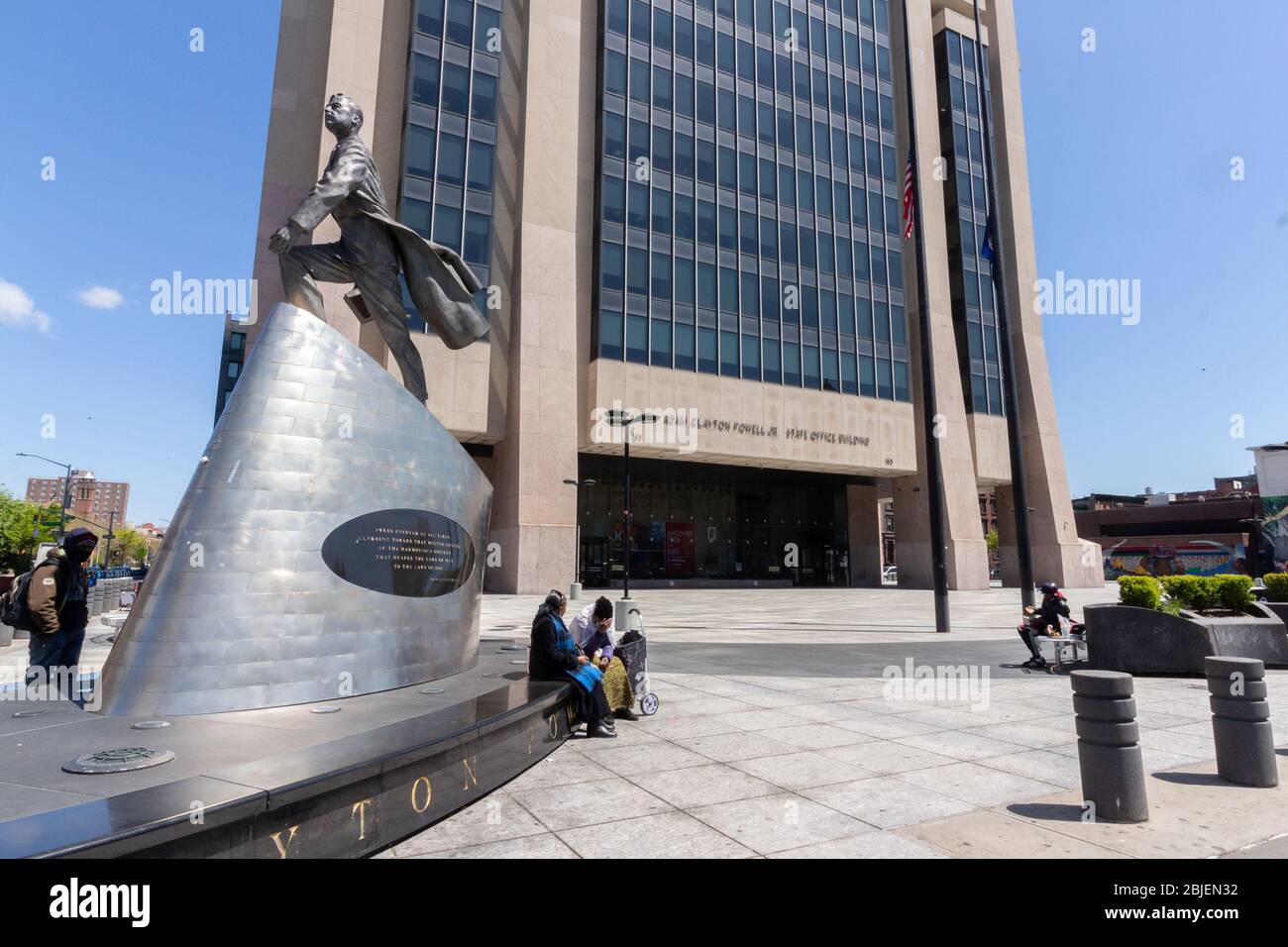 in Harlem people gather around a statue of Adam Clayton Powell in the plaza of the New York State government office building bearing his name Stock Photo