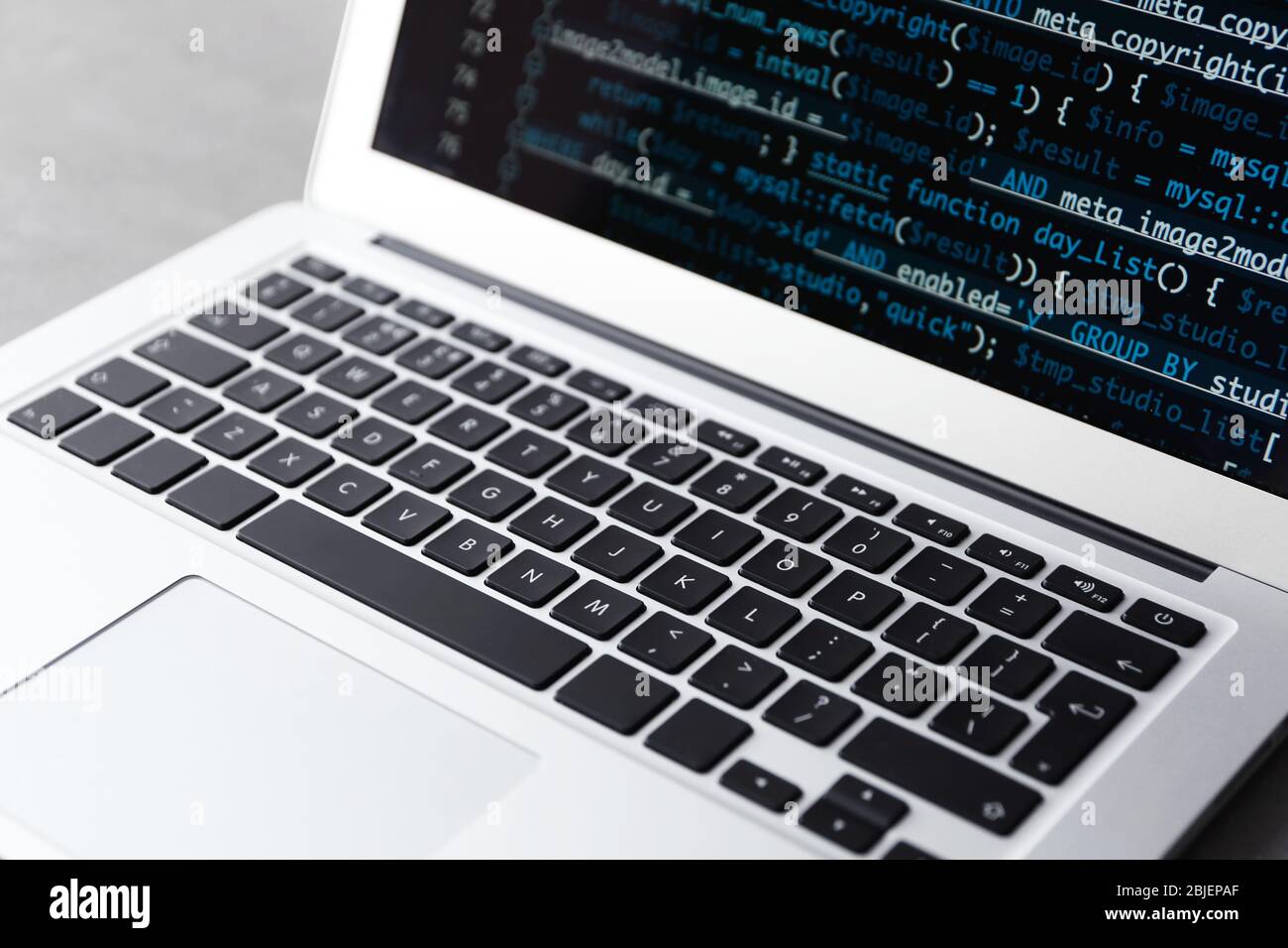 Laptop of programmer with script code on display Stock Photo