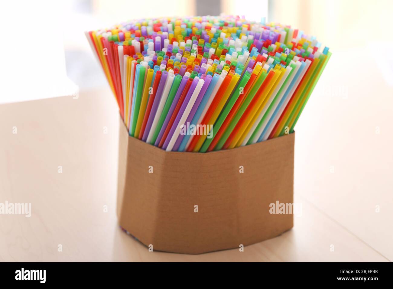 Colorful straws for drinks in box on table Stock Photo