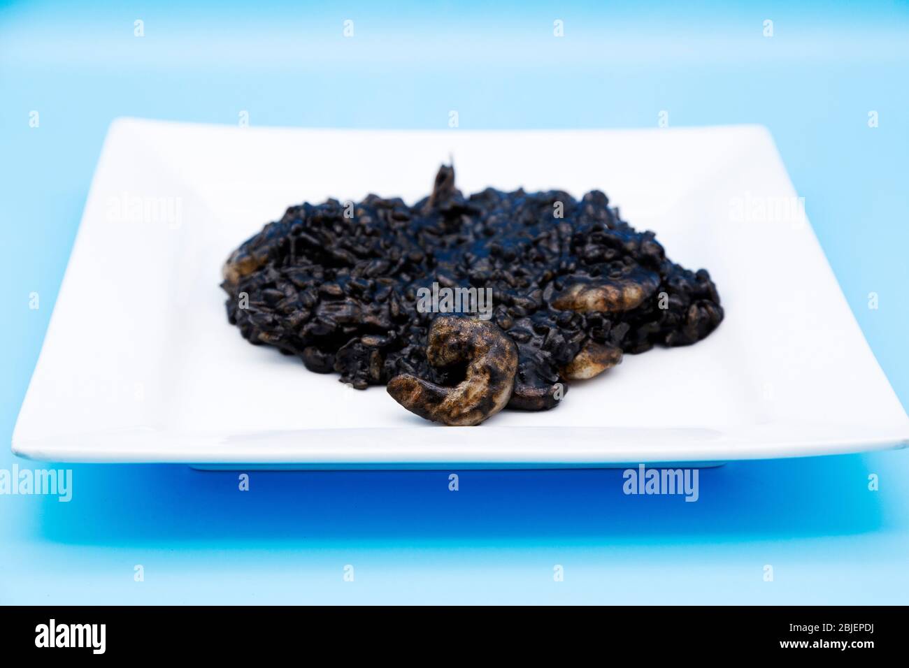 Home-cooked black risotto, a rice dish made with seafood. The dish is blackened by squid ink and known as crni rižot in Croatia, where it originates. Stock Photo