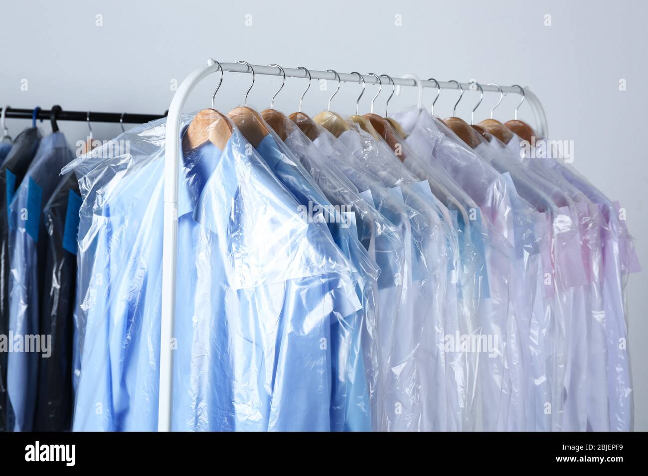 https://c8.alamy.com/comp/2BJEPF9/rack-of-clean-clothes-hanging-on-hangers-at-dry-cleaning-2BJEPF9.jpg