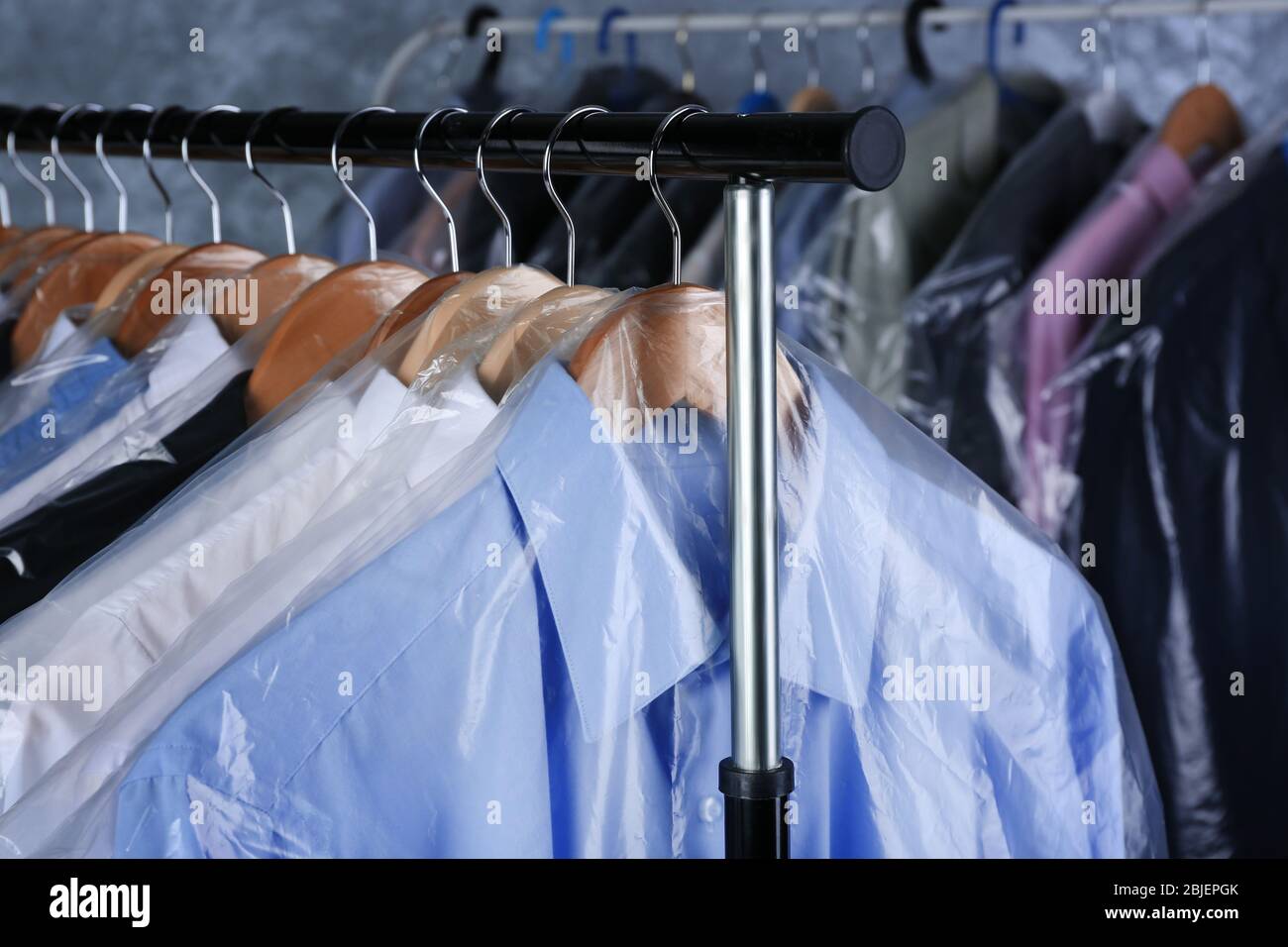 Rack of clean clothes hanging on hangers at dry-cleaning Stock Photo ...