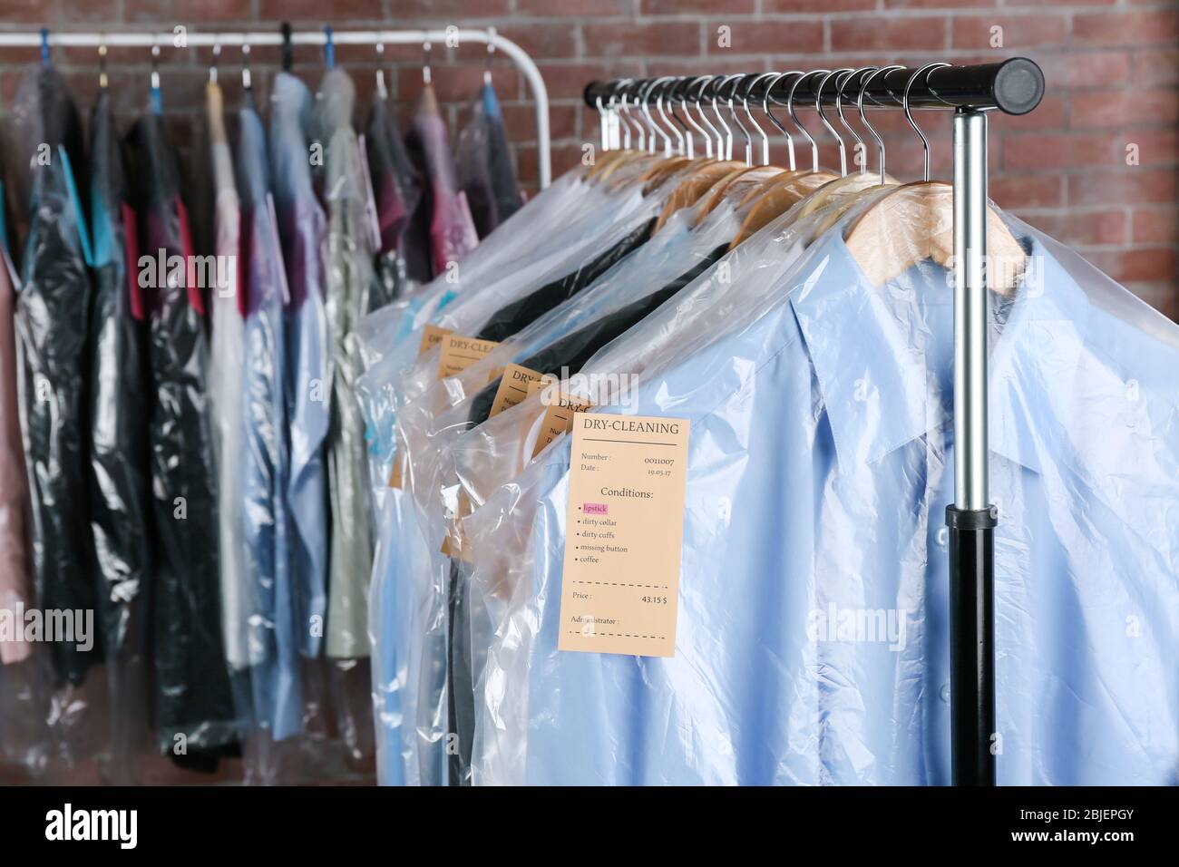 https://c8.alamy.com/comp/2BJEPGY/rack-of-clean-clothes-hanging-on-hangers-at-dry-cleaning-2BJEPGY.jpg