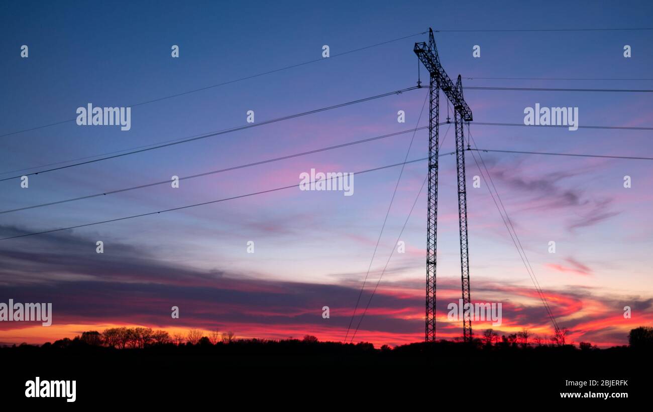 Silhouette of high voltage electric tower at beautiful sunset with ...
