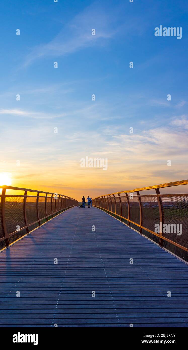 Hortobagy Hungary 04 20 2019: Tourists take photos on the wooden bridge at beautiful sunset. Stock Photo