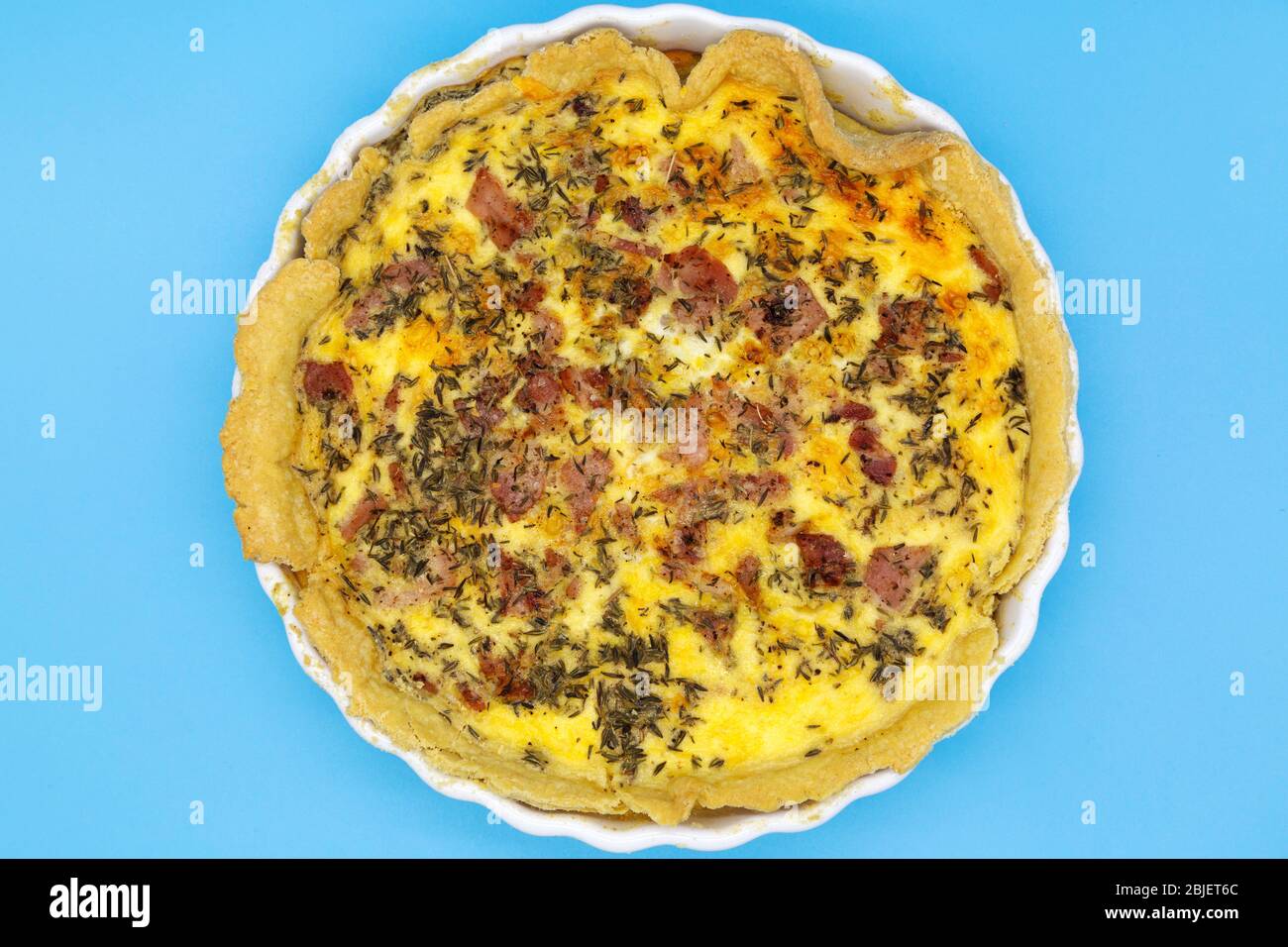 Home-baked Quiche Lorraine. The dish is made with cheese, eggs, cream and bacon and baked in pastry. Stock Photo