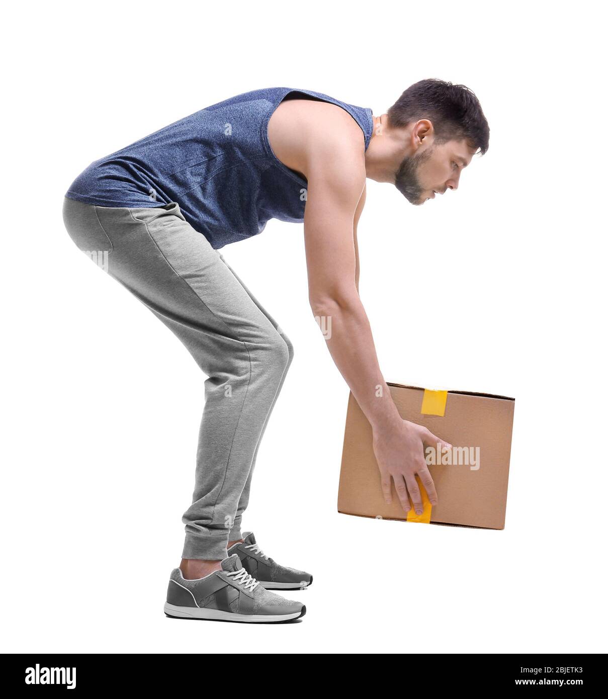 Posture concept. Man lifting heavy cardboard box against white background Stock Photo