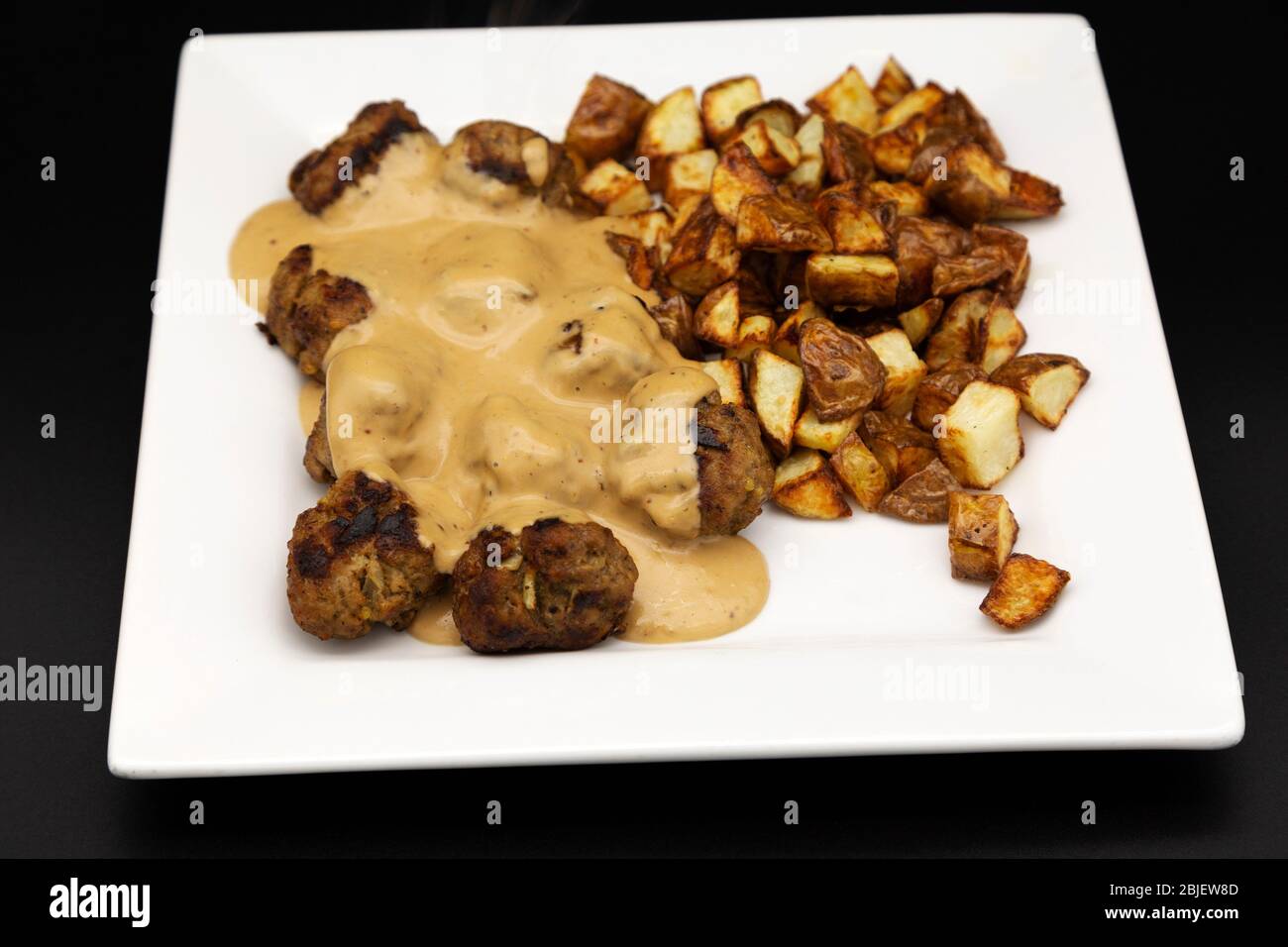 A plate of home-cooked Swedish style meatballs (Svenska Kottbullar) and creamy sauce made to the recipe published by Ikea. Stock Photo