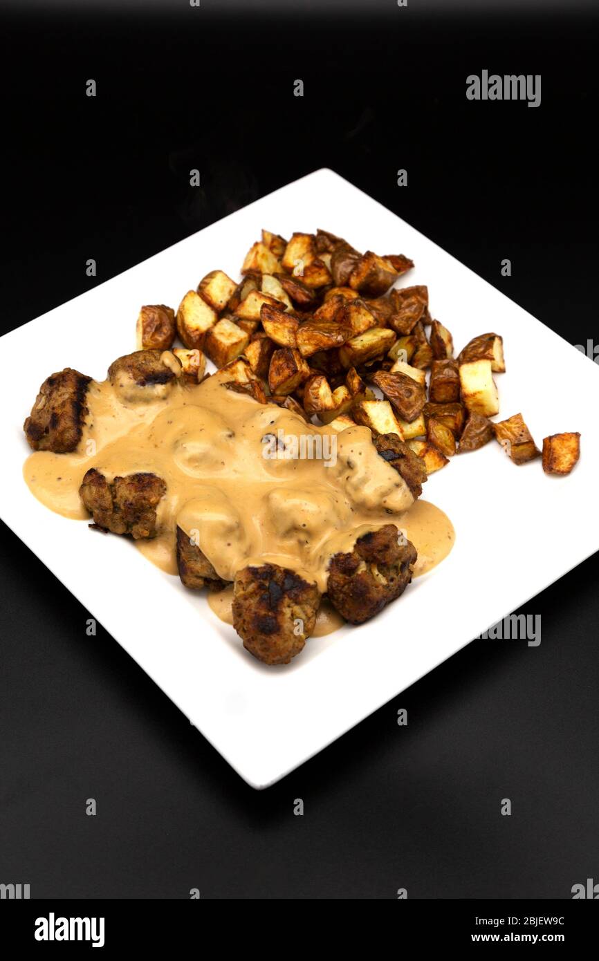 A plate of home-cooked Swedish style meatballs (Svenska Kottbullar) and creamy sauce made to the recipe published by Ikea. Stock Photo
