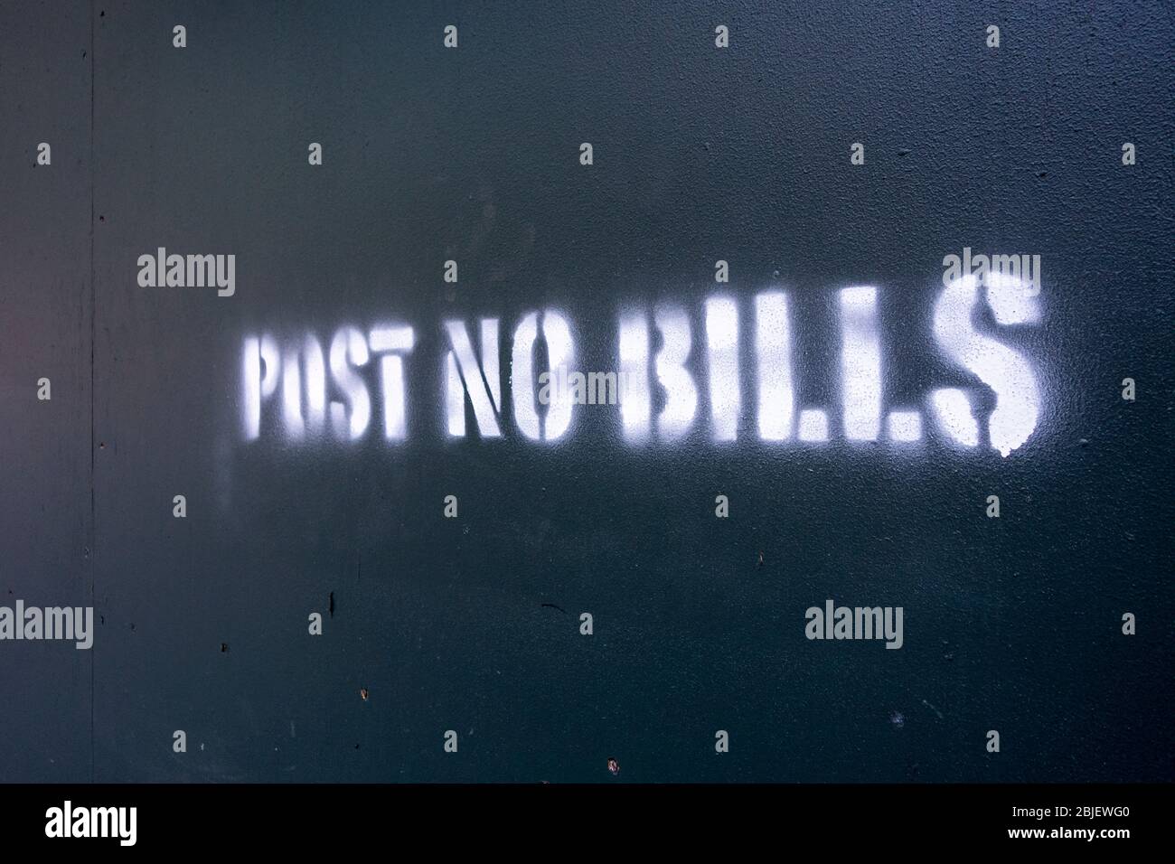 Post No Bills spray painted on green plywood around a contrution sight Stock Photo