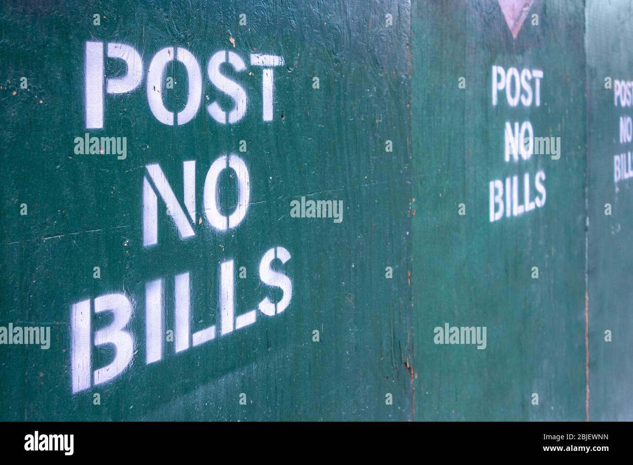 post no bills spray painted text letters on closed off urban construction area Stock Photo
