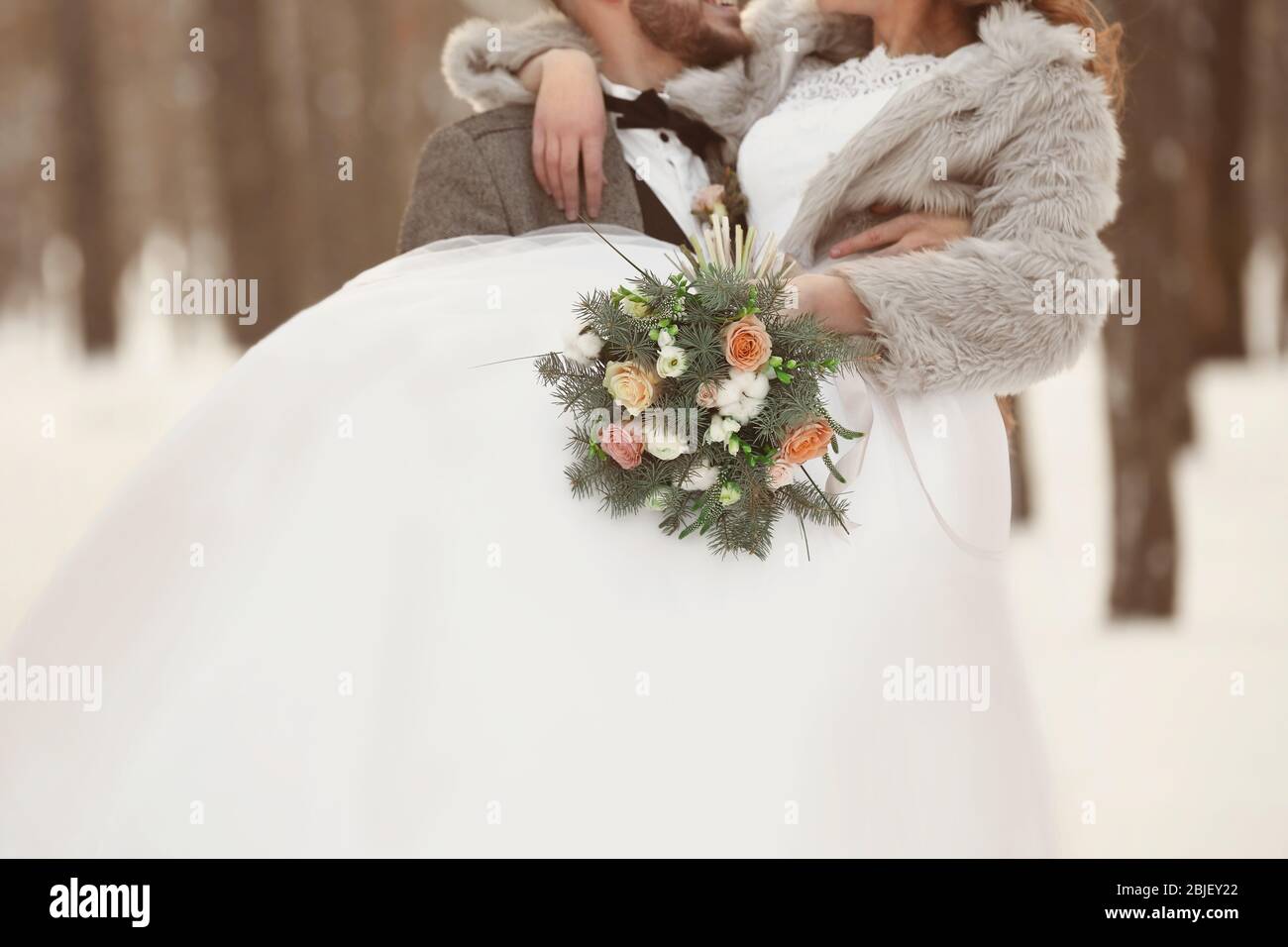 Happy wedding couple with bouquet outdoors on winter day Stock Photo ...