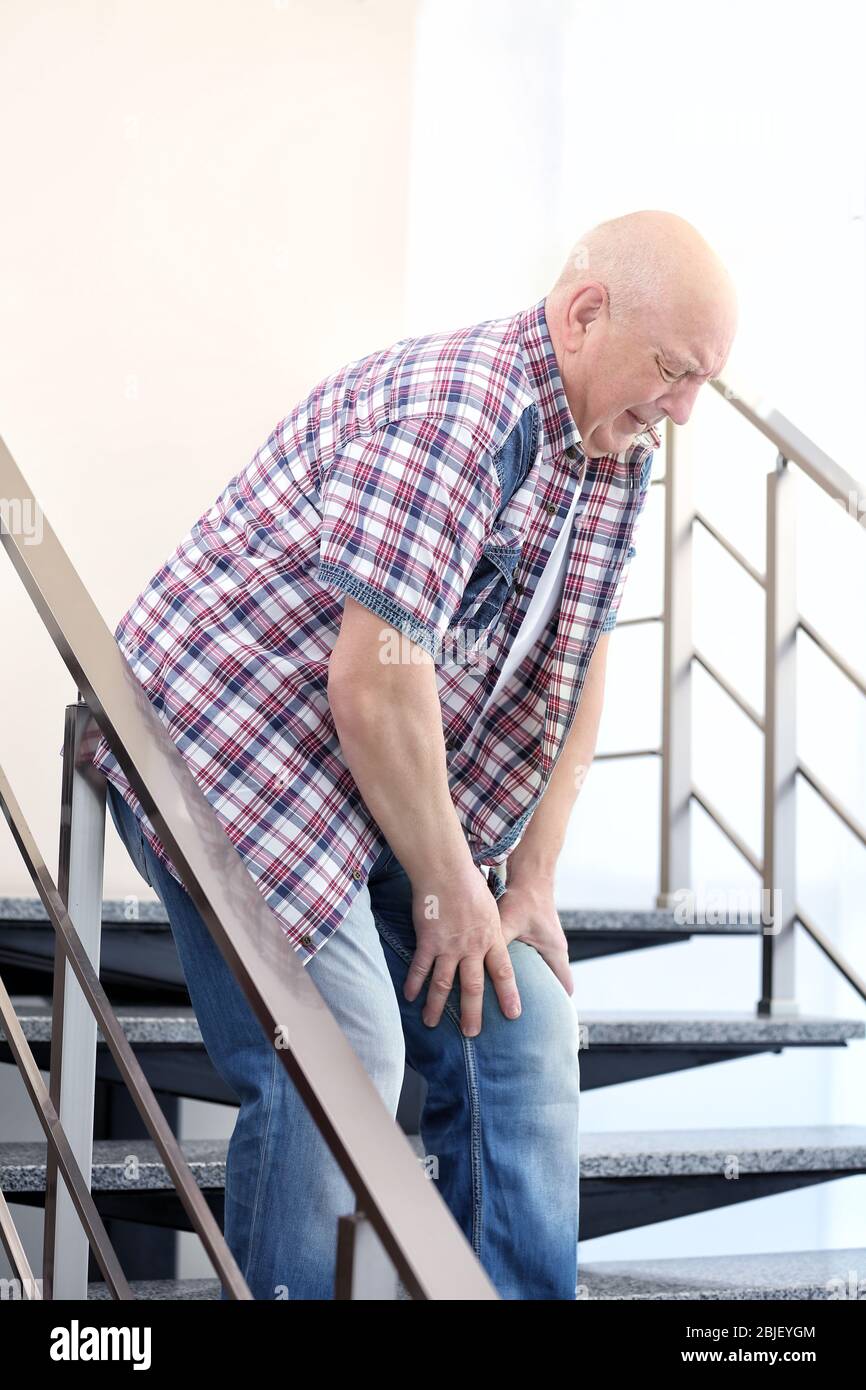 Mature man suffering from pain on stairs Stock Photo - Alamy