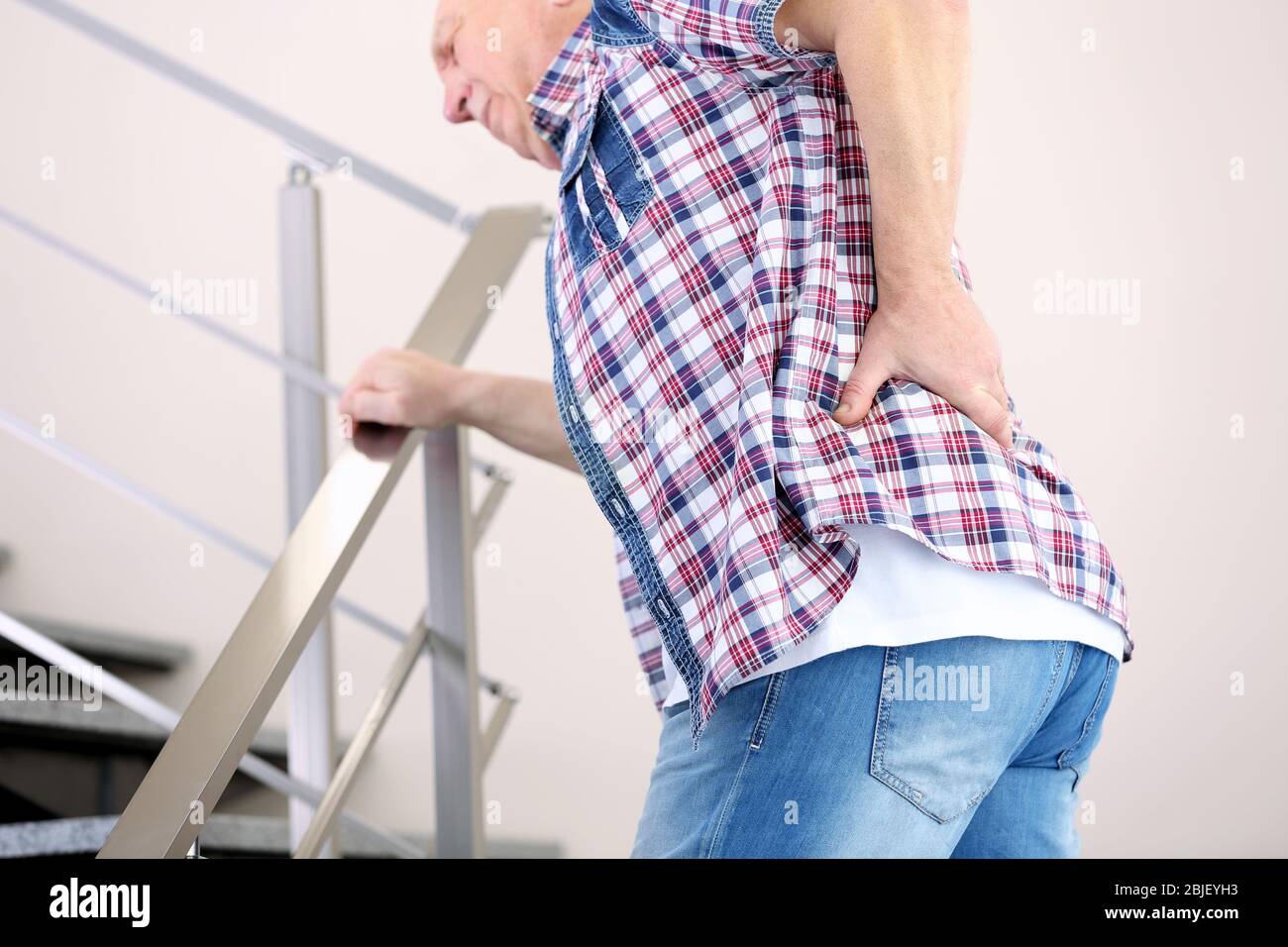 Mature man suffering from pain on stairs Stock Photo - Alamy