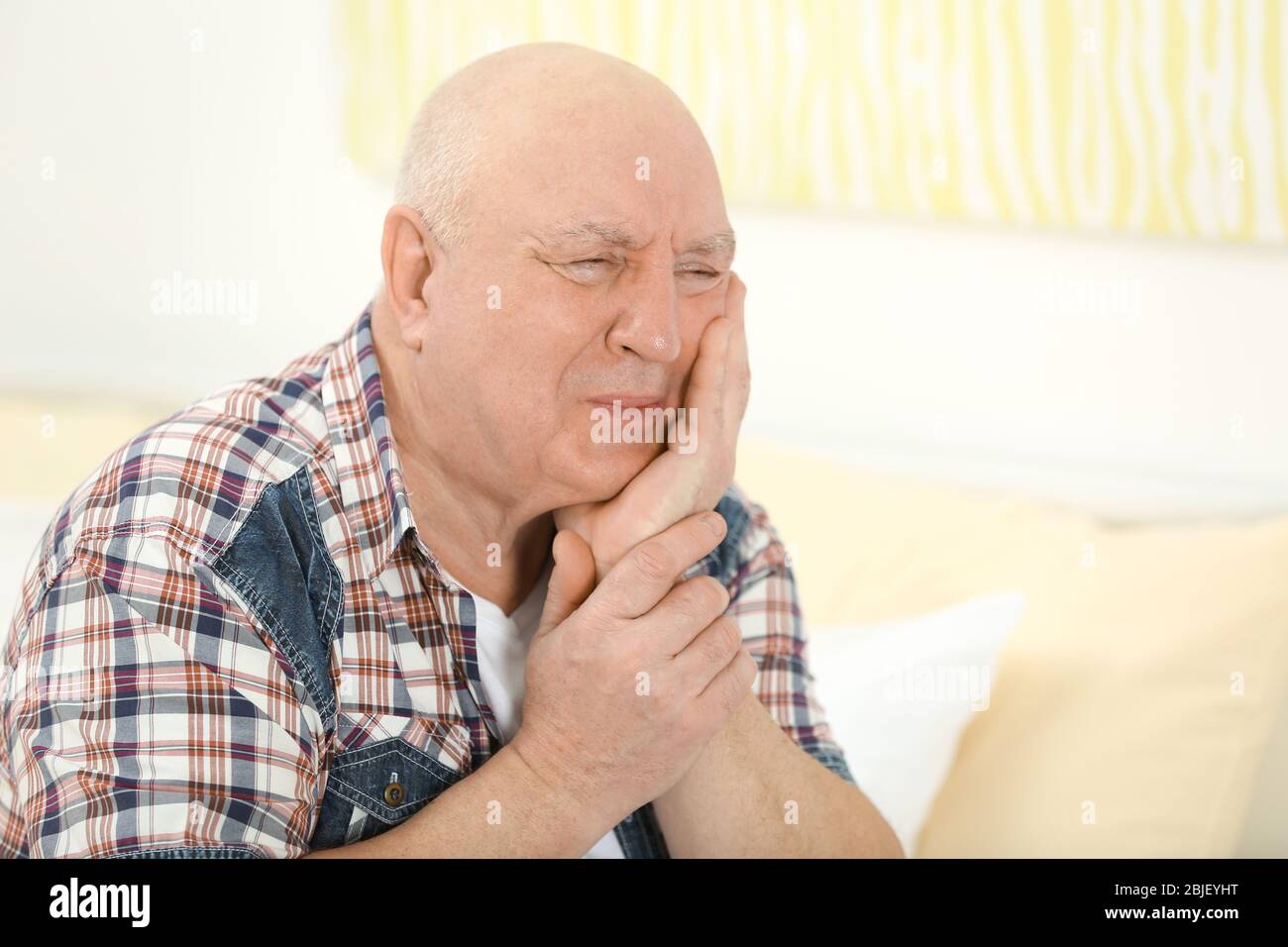 Mature man suffering from pain at home Stock Photo