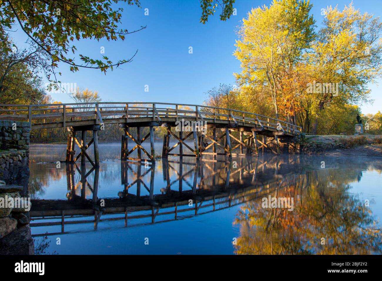 Autumn color in the maple trees at dawn over the Old North Bridge, Concord, Massachusetts, USA Stock Photo