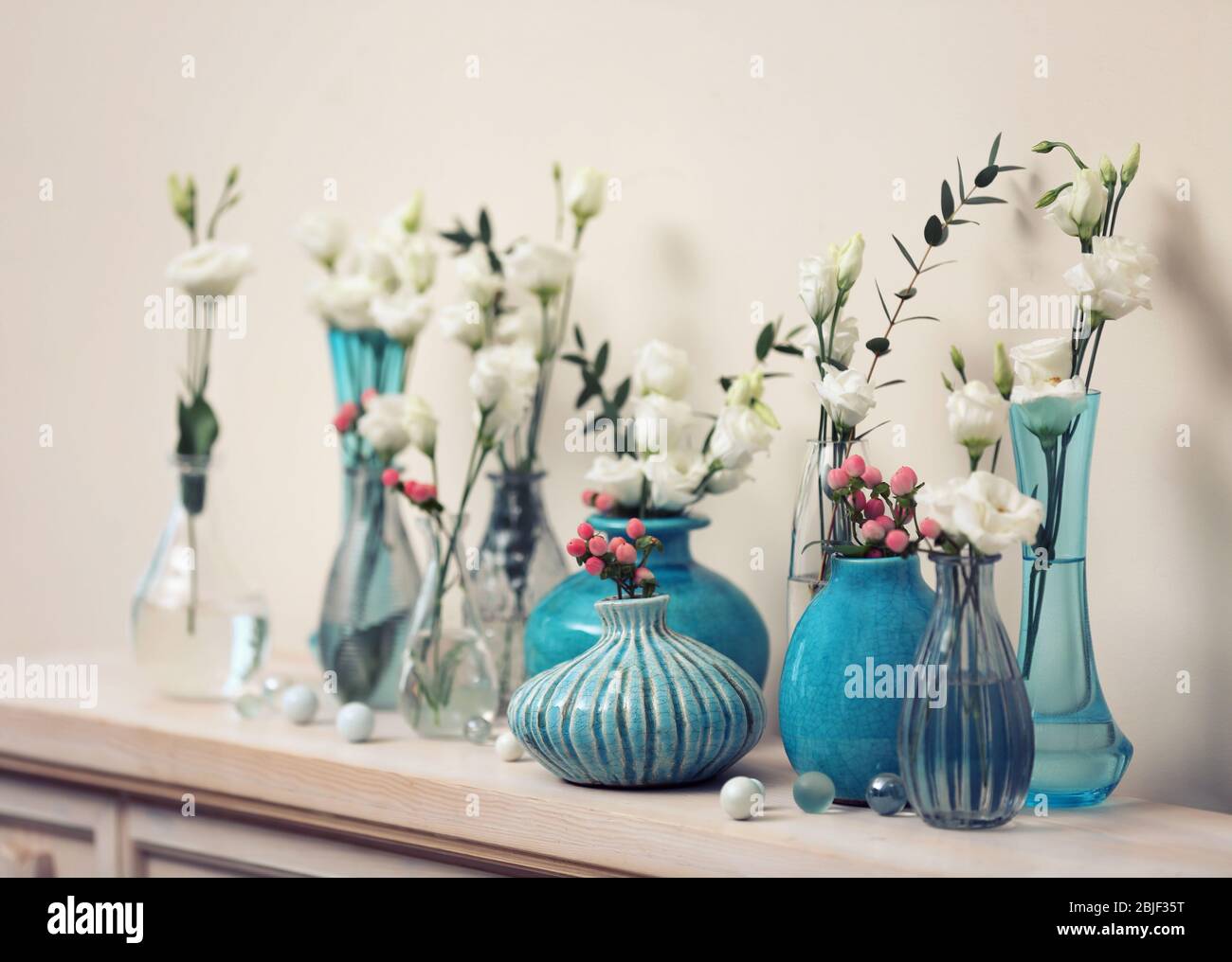 Beautiful composition with fresh flowers in vases on mantelpiece Stock  Photo - Alamy
