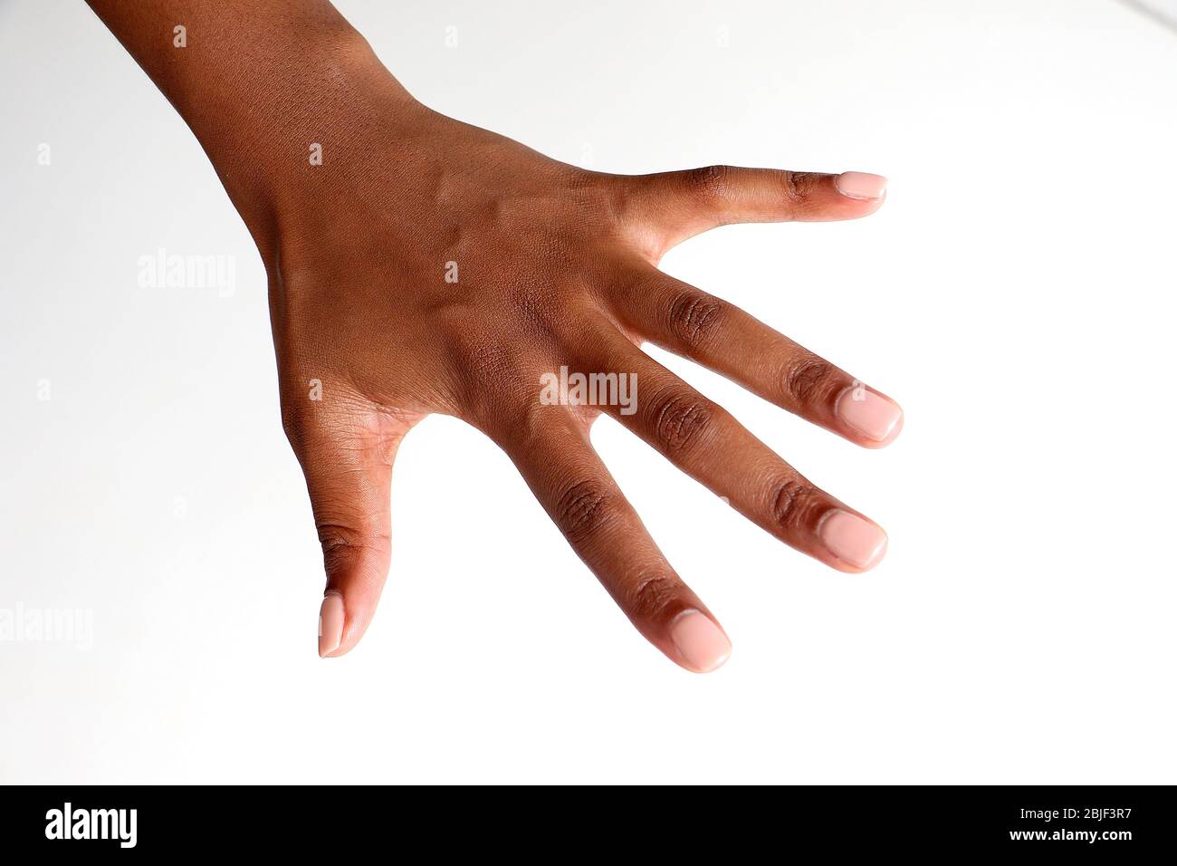 Isolated female black african indian hand facing downwards showing manicured nails Stock Photo