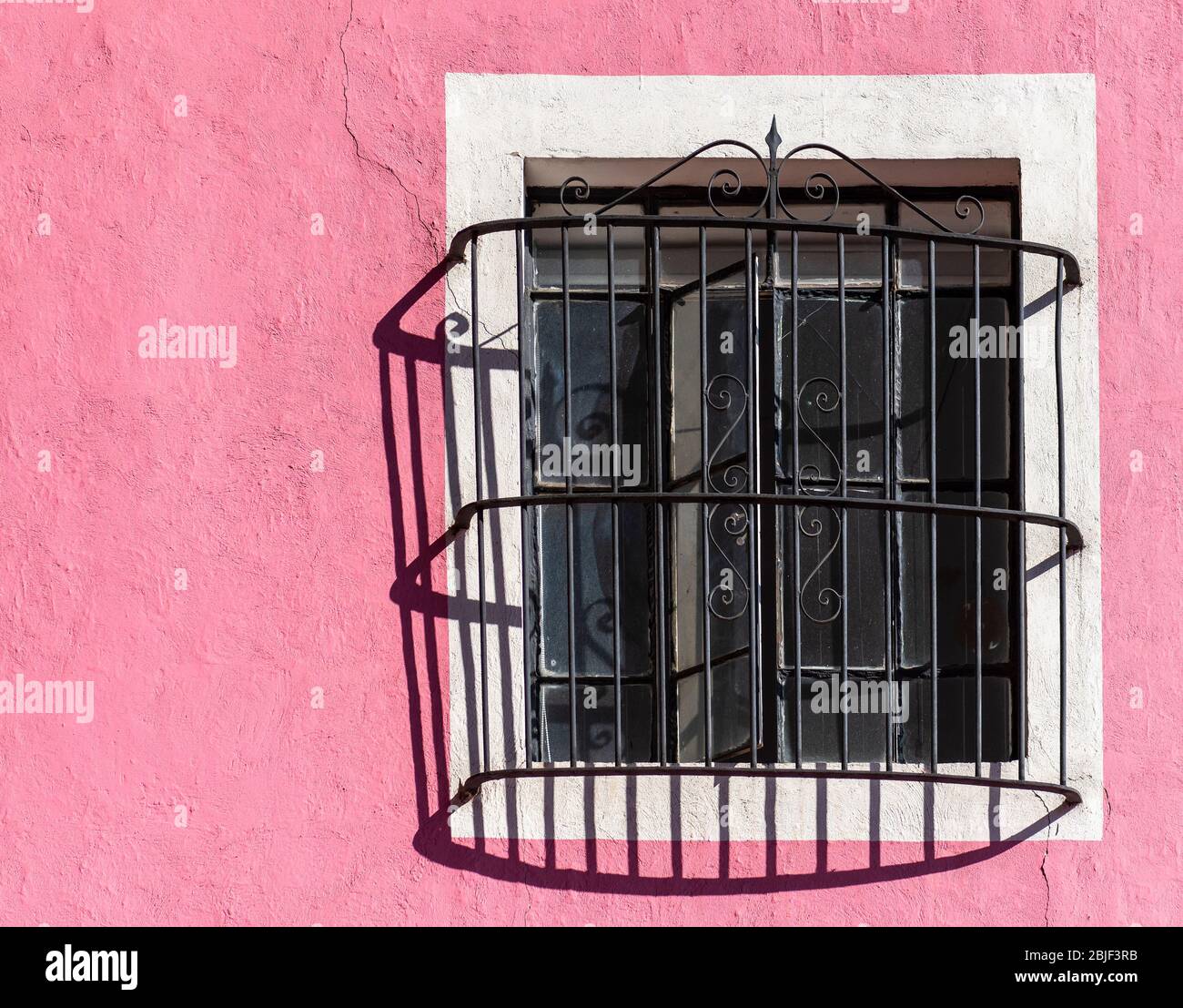 Pink facade with window and cast iron decoration, Puebla, Mexico. Stock Photo