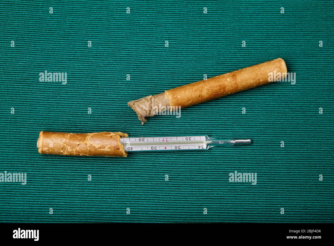 Old mercury thermometer measuring a persons body temperature, on a