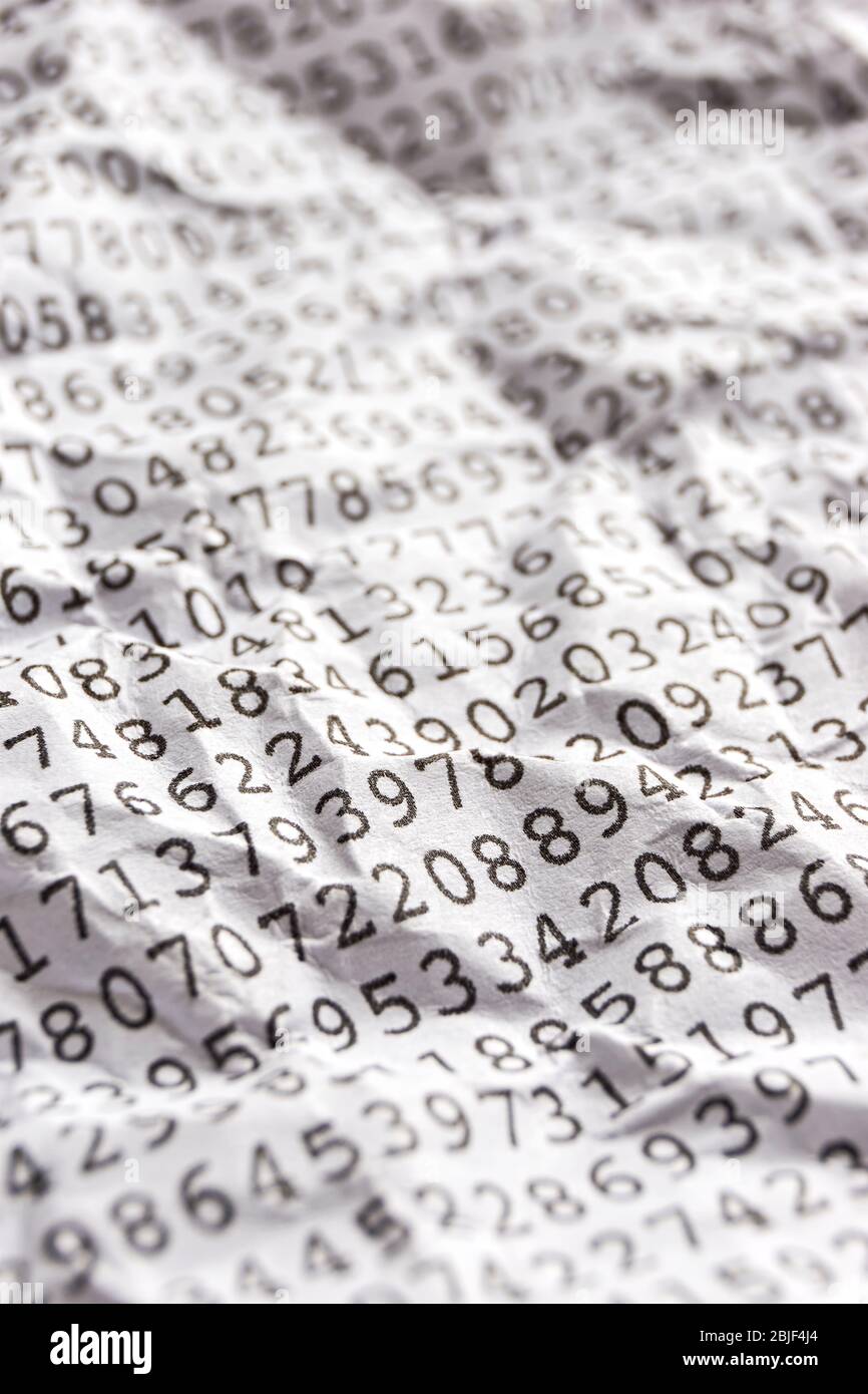 Background with black printed random monospace numbers on crumpled white paper for use as a template for a financial report. Vertical image. Stock Photo