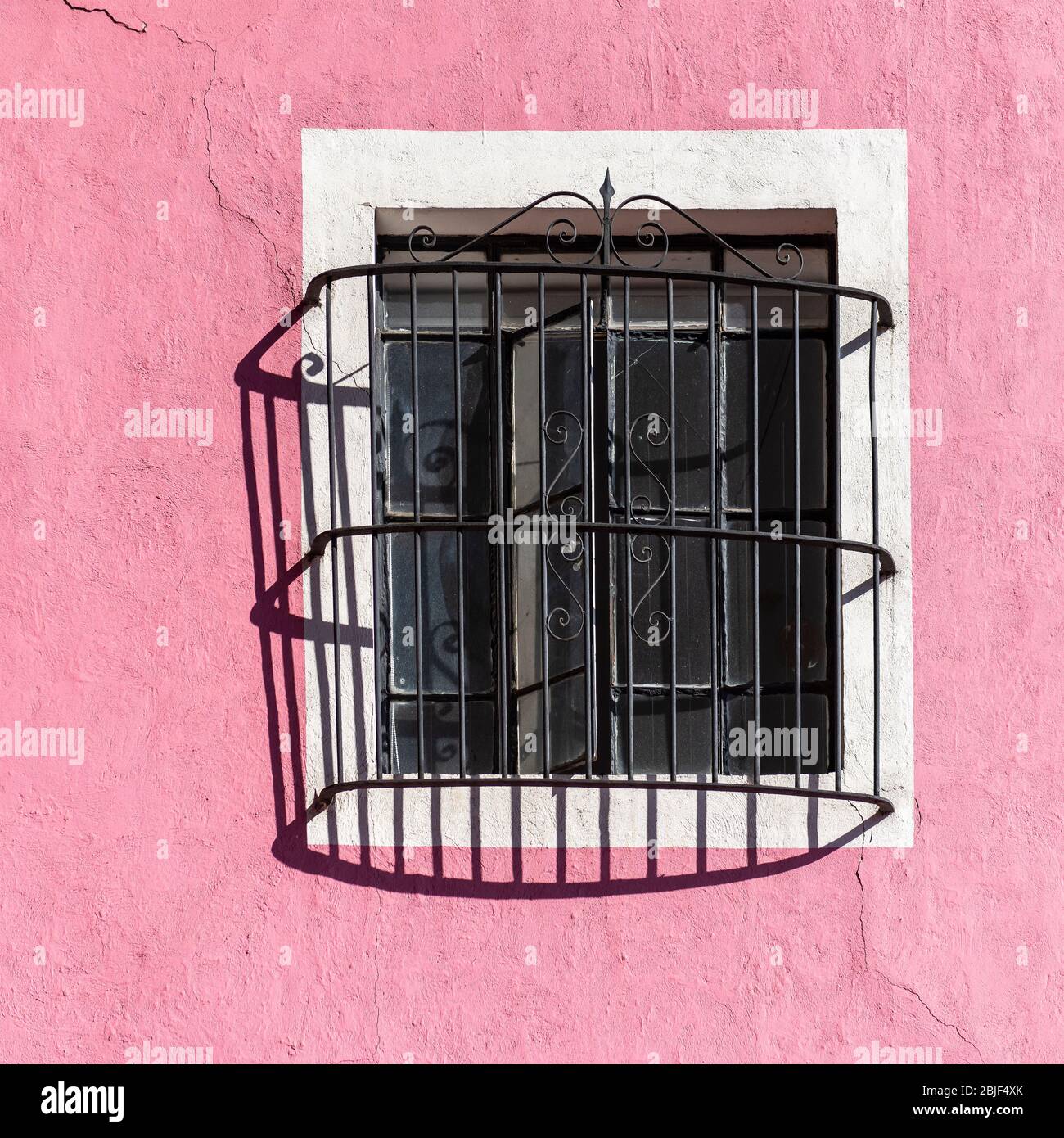 Pink Facade with Window and Wrought Iron Decoration in Puebla, Mexico. Stock Photo
