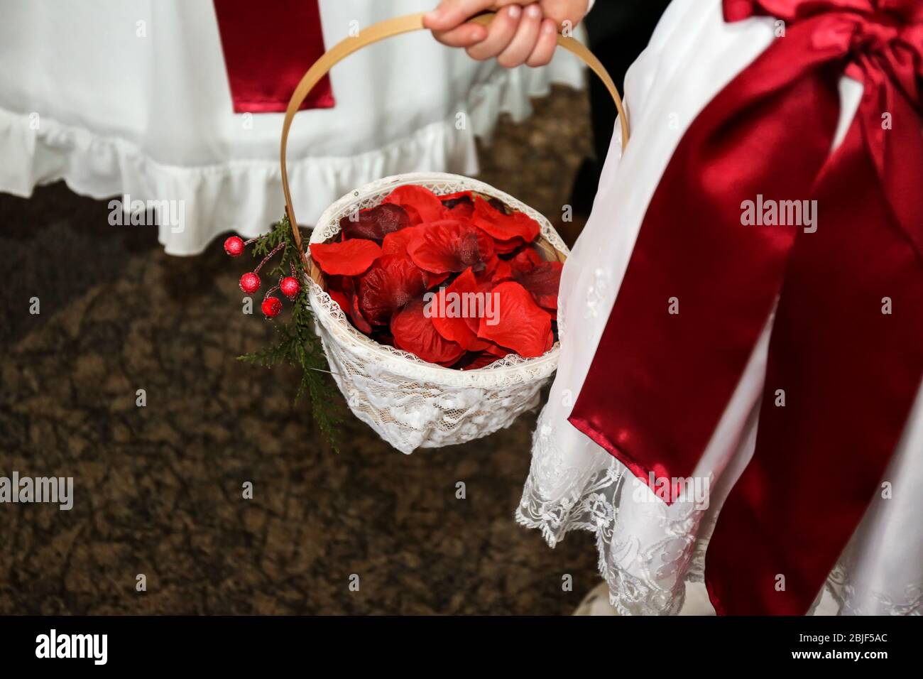 Cute girl holding basket with rose petals on wedding ceremony Stock Photo -  Alamy