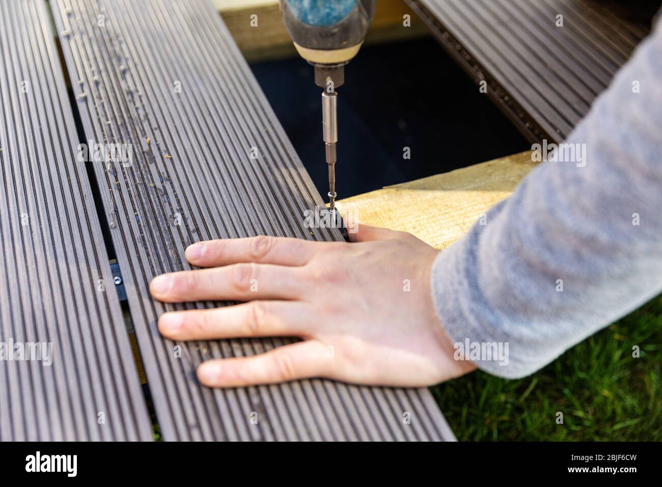 terrace deck construction - man installing wpc composite decking boards Stock Photo