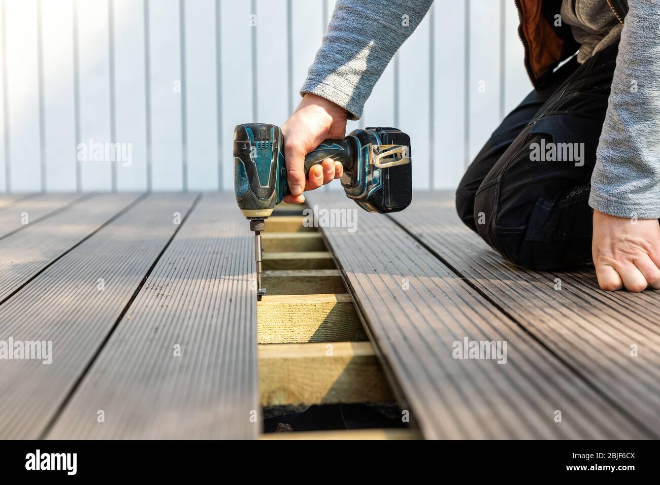 terrace deck construction man installing wpc composite decking boards