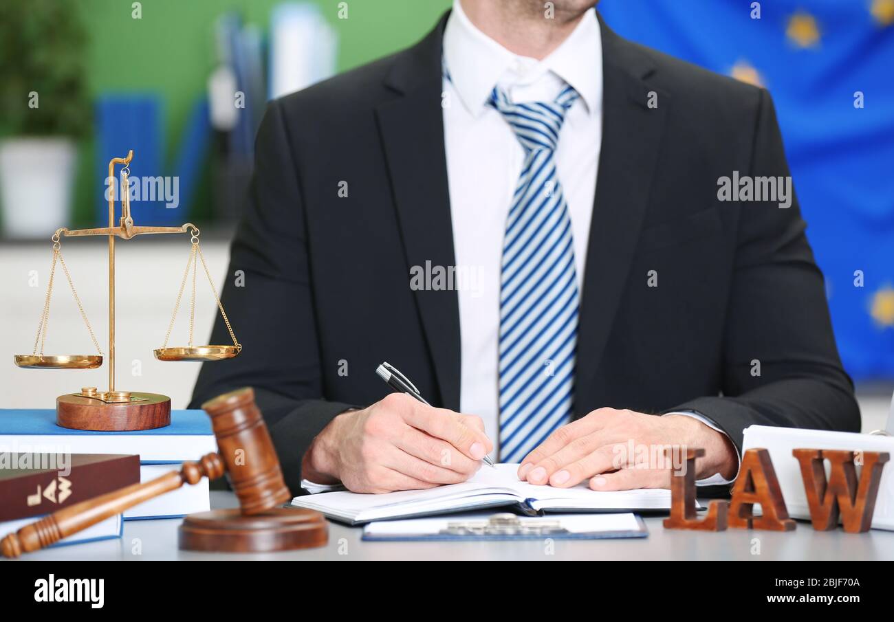 Male judge working with document and law accessories on table Stock