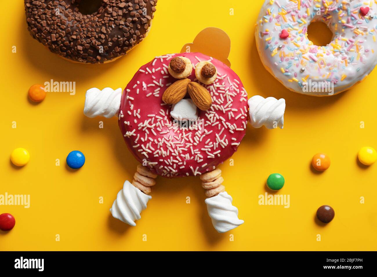 Funny decorated donut on color background Stock Photo