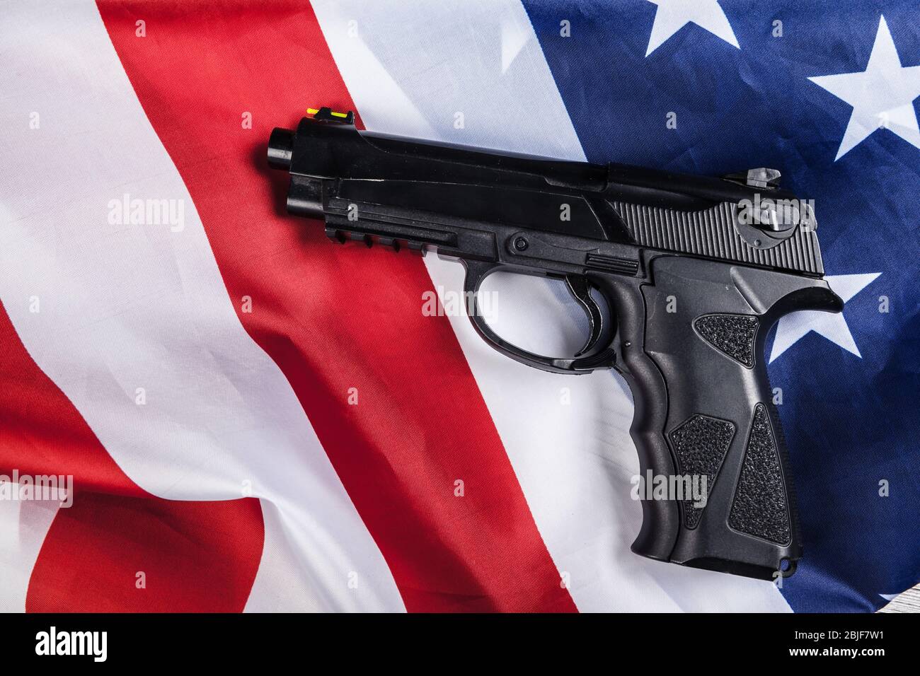 Handgun lying on American flag. Weapon problem concept Stock Photo
