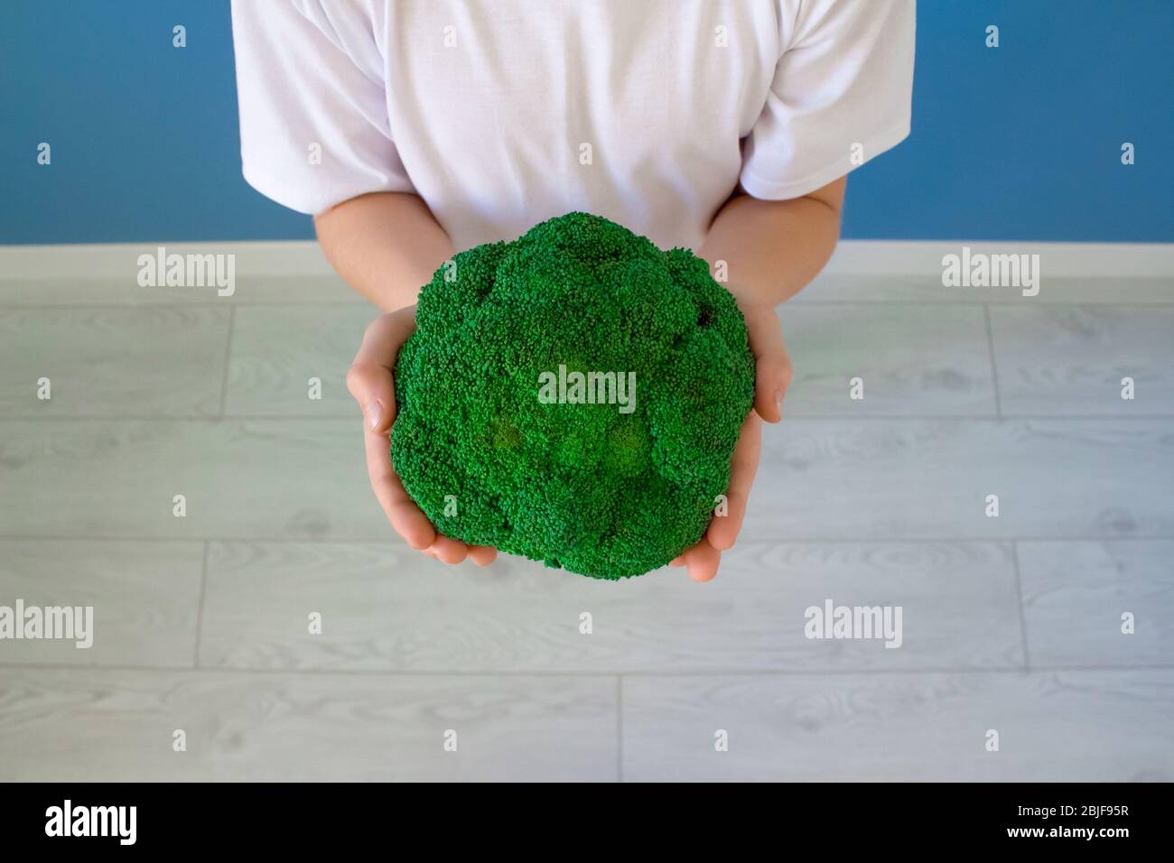 child-s-hands-holding-fresh-broccoli-healthy-vegetarian-food-for-kids