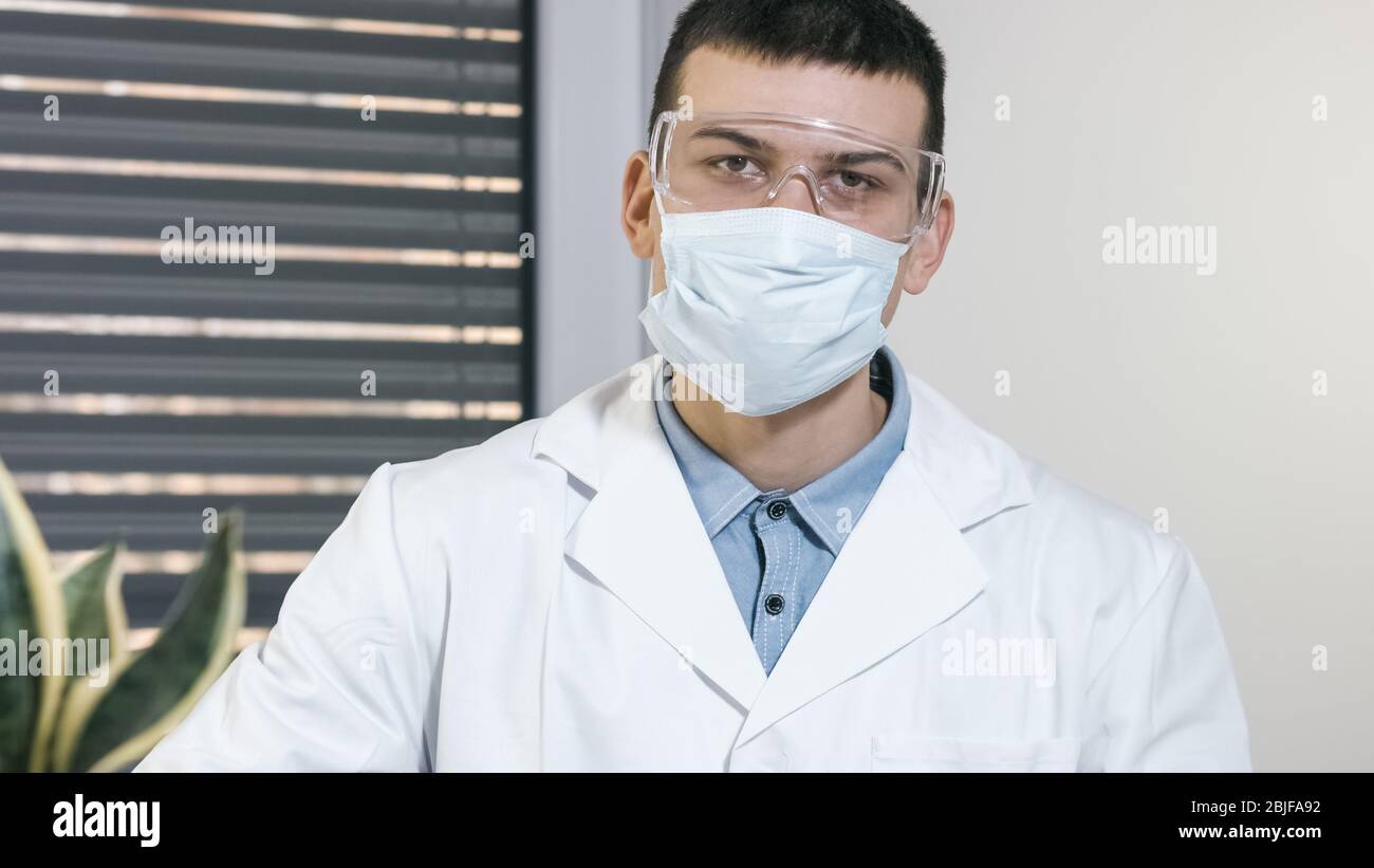 Young male doctor scientist with mask portrait in hospital Stock Photo