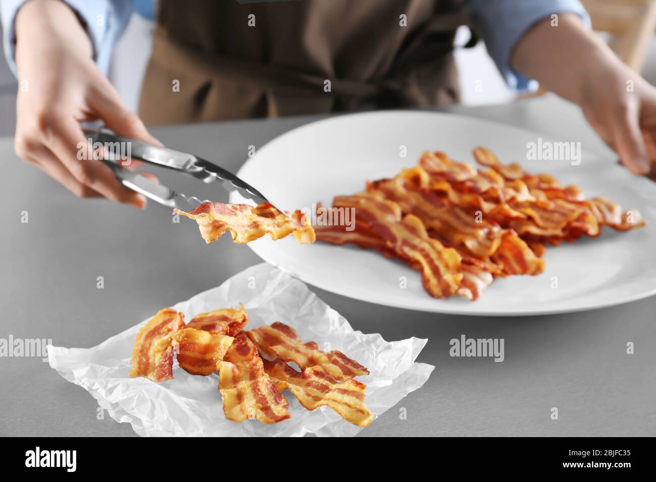 woman-holding-tasty-bacon-slice-with-ton