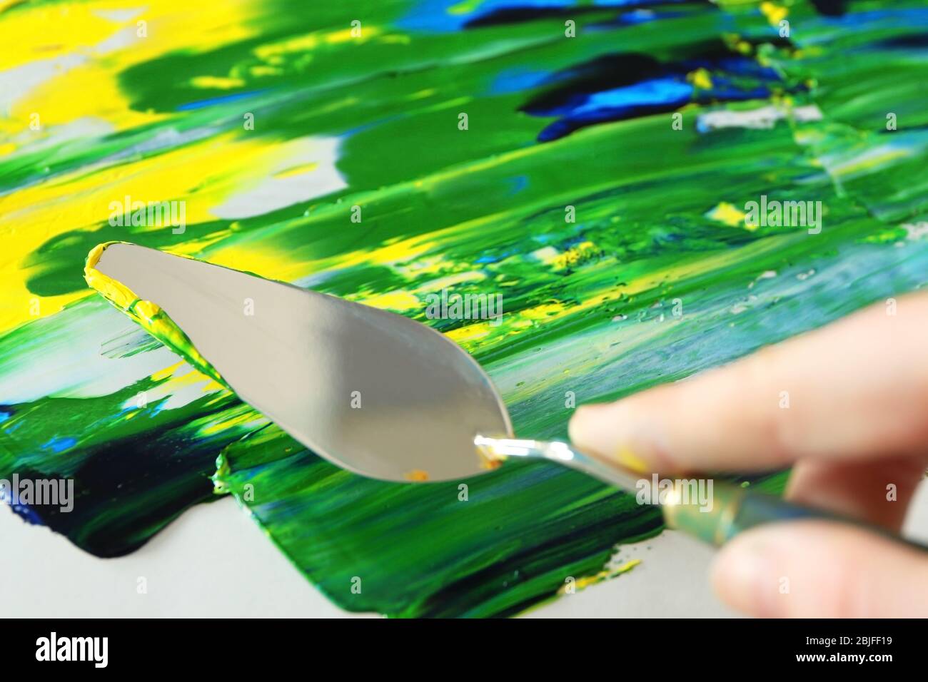 Woman using palette knife in oil painting Stock Photo - Alamy