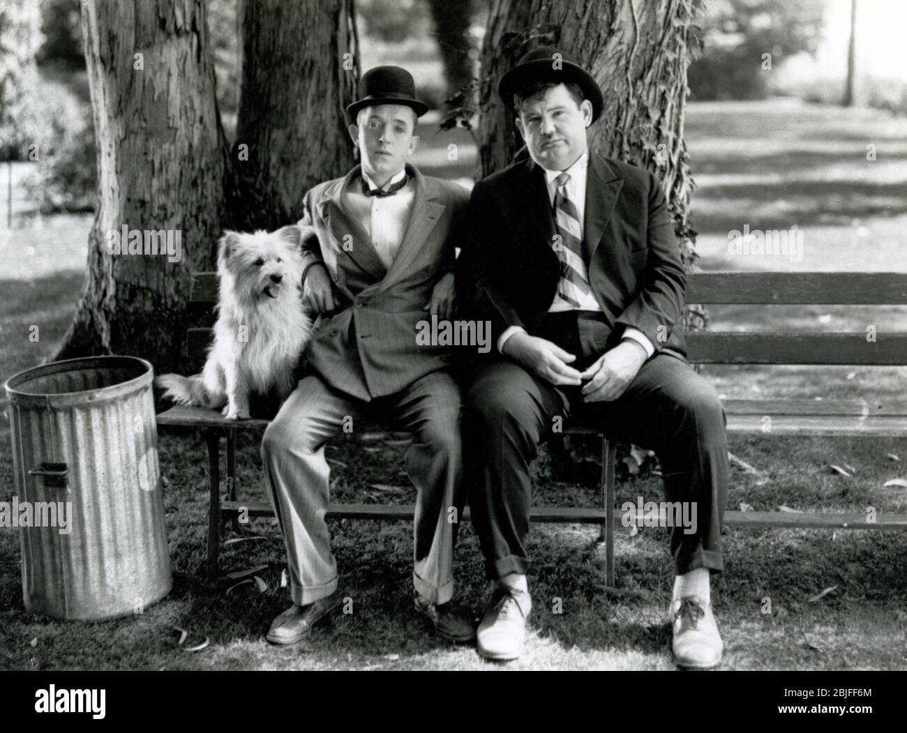 Laurel and Hardy sitting on a park bench in a scene from a classic silent comedy short subject, 'Early to Bed', 1928 from MGM. Stock Photo