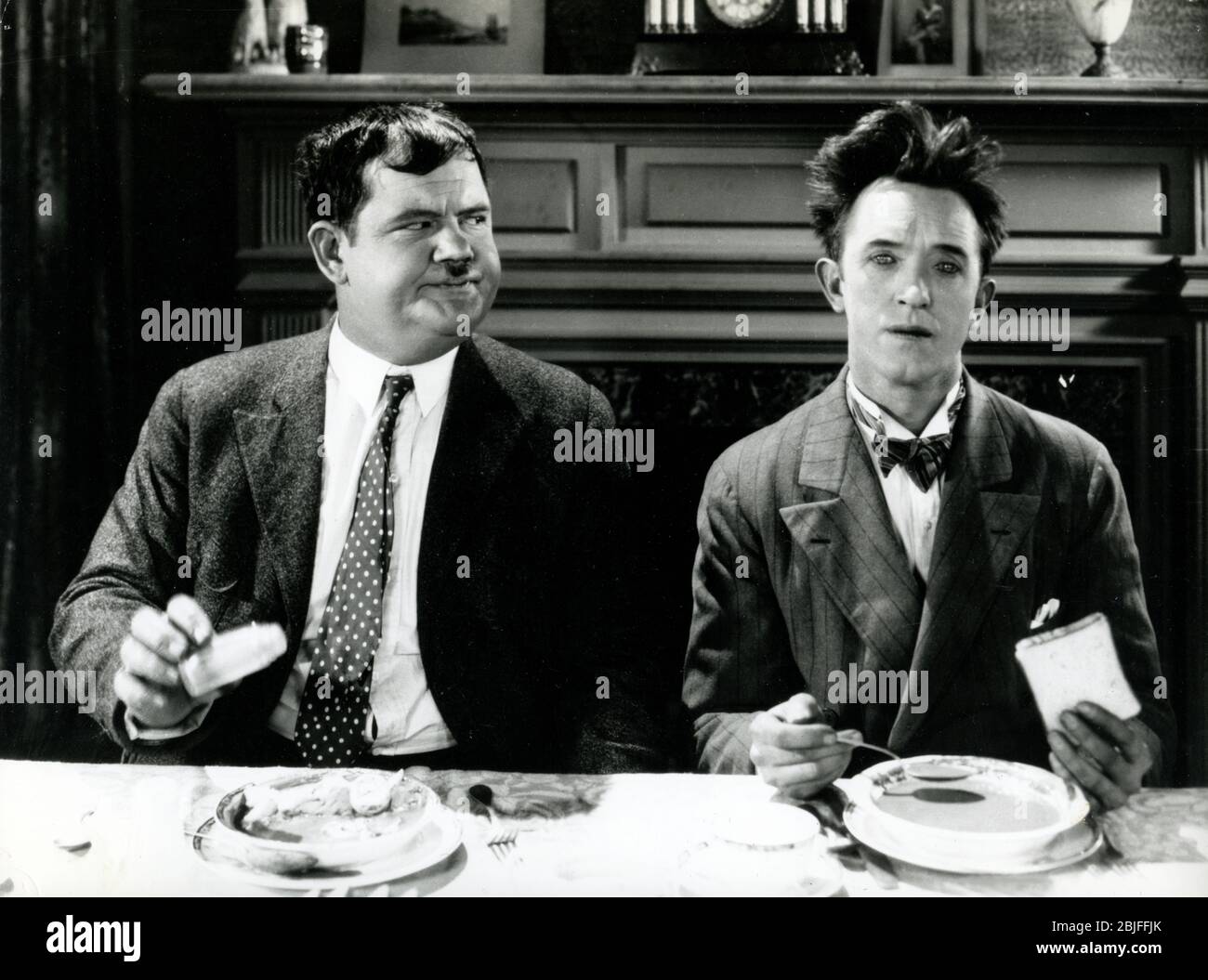 Laurel and Hardy at dinner table in a scene from "You're Darn Tootin",  a  silent short subject  classic MGM Hollywood comedy movie released in 1928. Stock Photo
