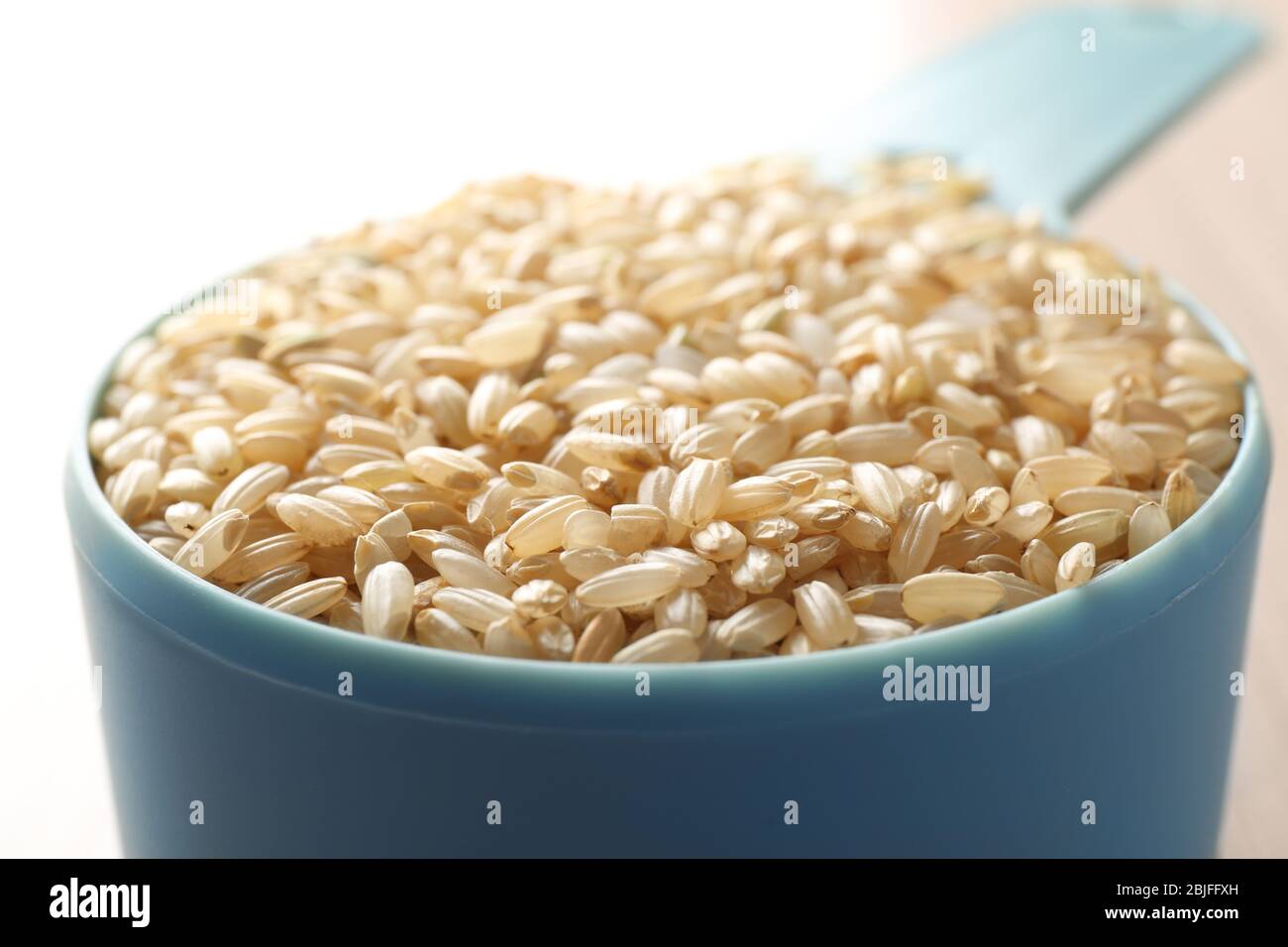 Measure scoop with brown rice closeup Stock Photo Alamy