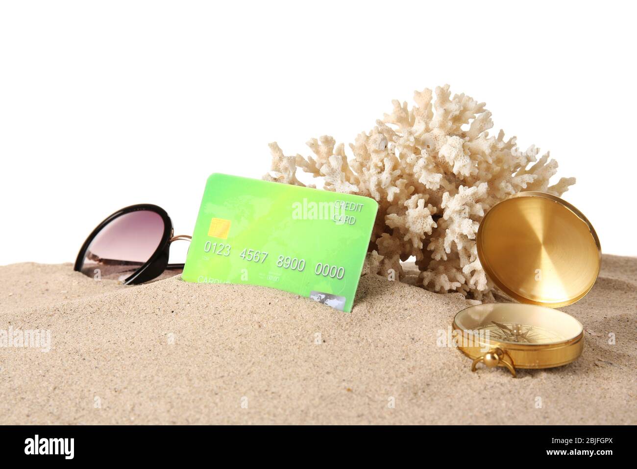 Sand with credit card, compass and coral on white background Stock Photo