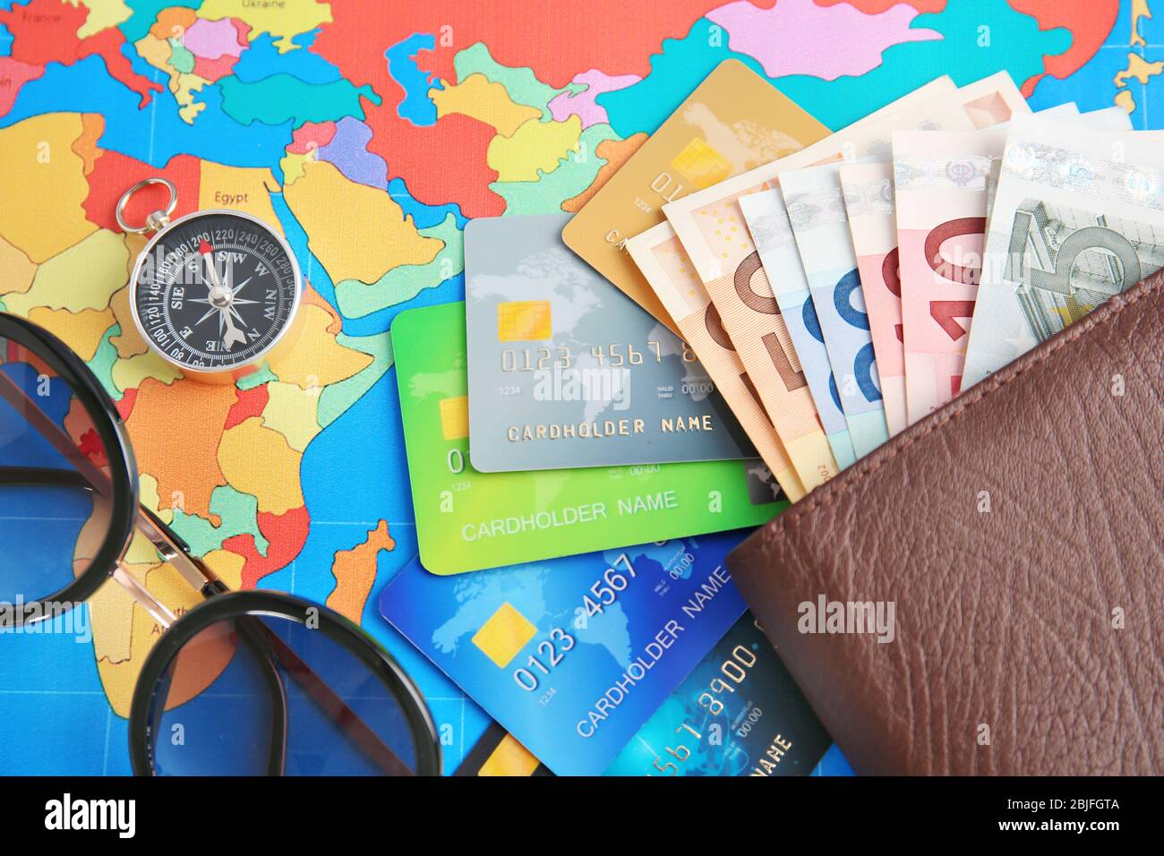 Credit cards with money in wallet on  world map background Stock Photo