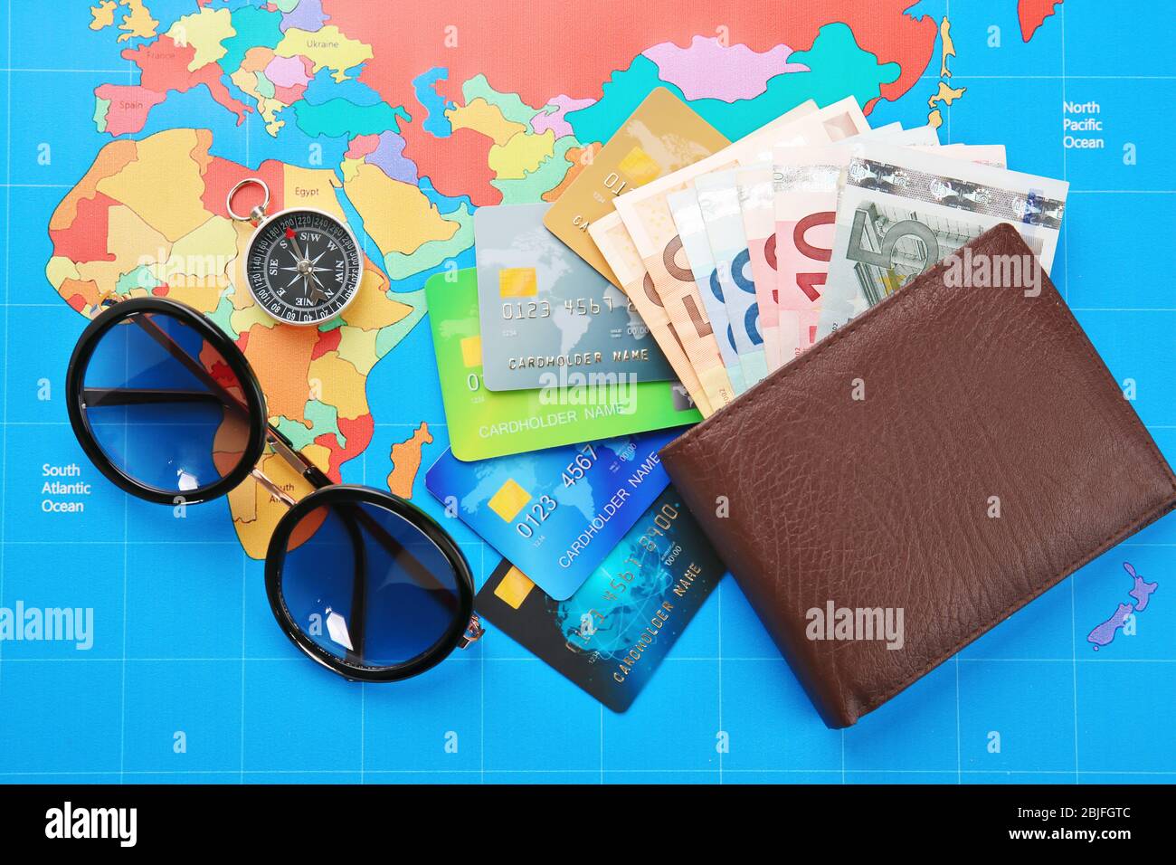 Credit cards with money in wallet on  world map background Stock Photo