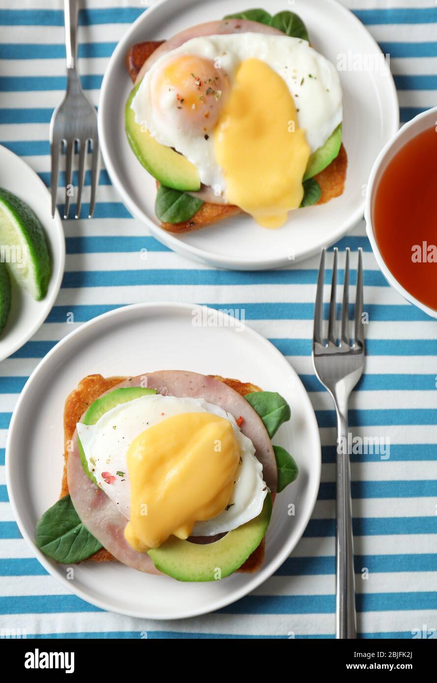 Plates with tasty eggs Benedict on table Stock Photo