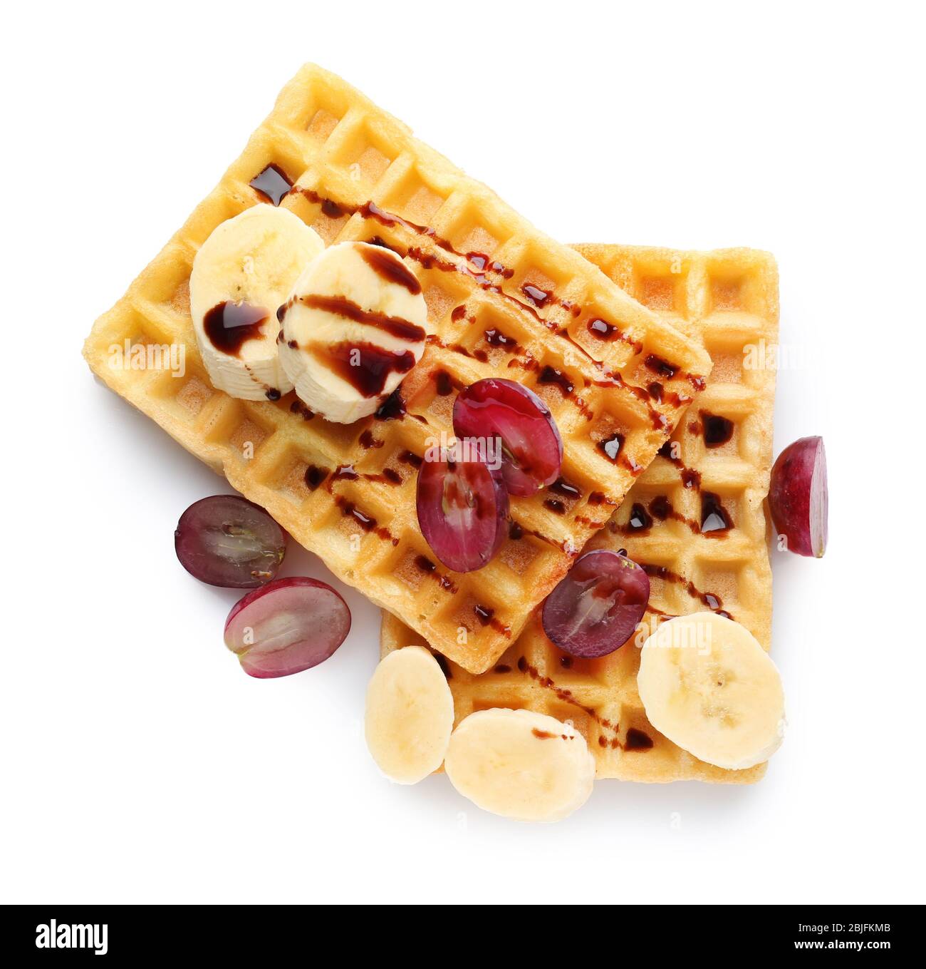 Tasty waffles with delicious fruits and syrup on white background Stock ...