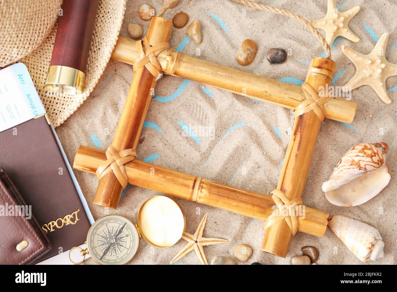 Travel concept. Composition of marine symbols and bamboo frame on sand background Stock Photo