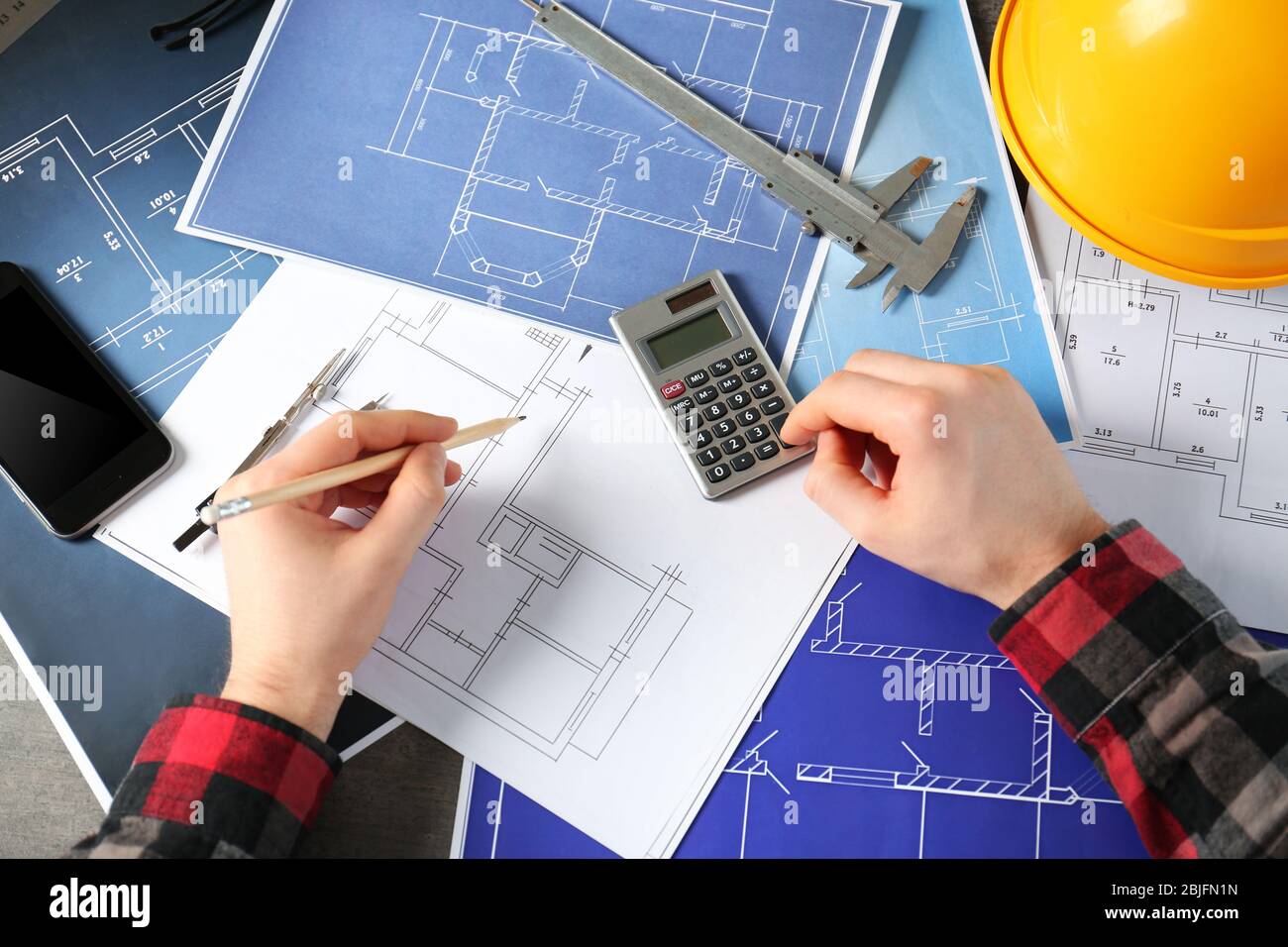 Male engineer hands working with blueprints on table Stock Photo