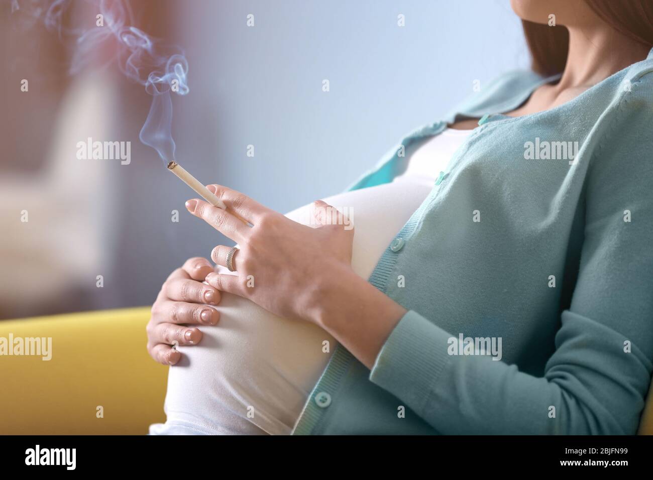 Pregnant woman smoking cigarette at home Stock Photo - Alamy